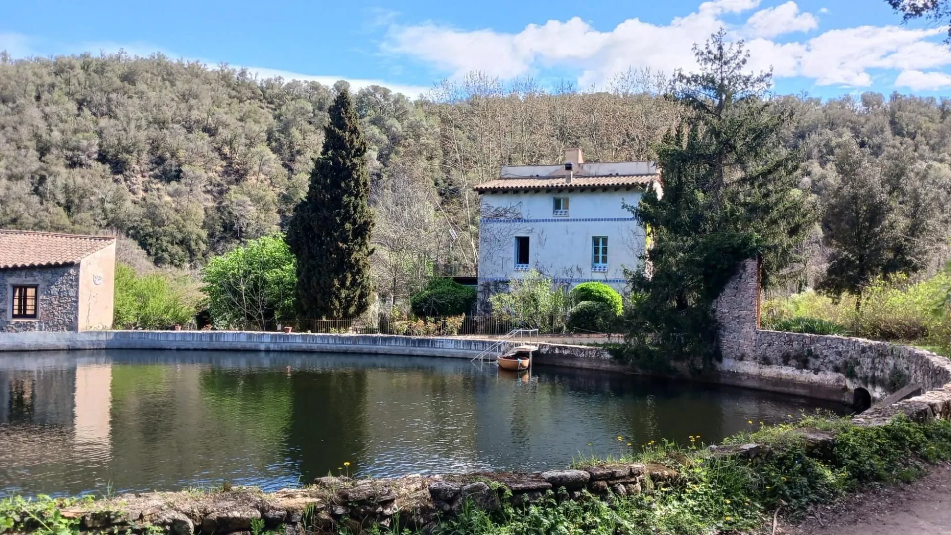 A stone masia beside a pond in the wooded country inland from Sant Feliu de Guíxols