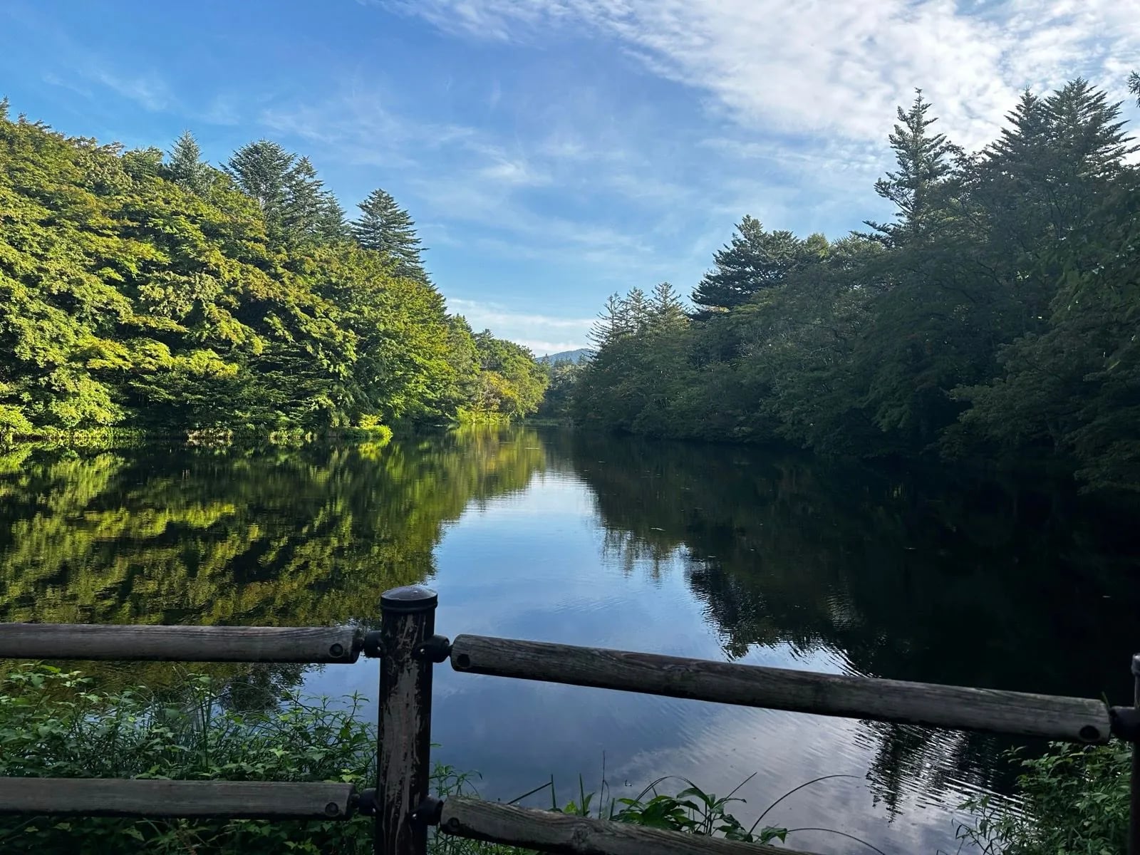 Ein stiller Fluss unter bewaldeten Hügeln am letzten Tag des Nakasendo-Wegs