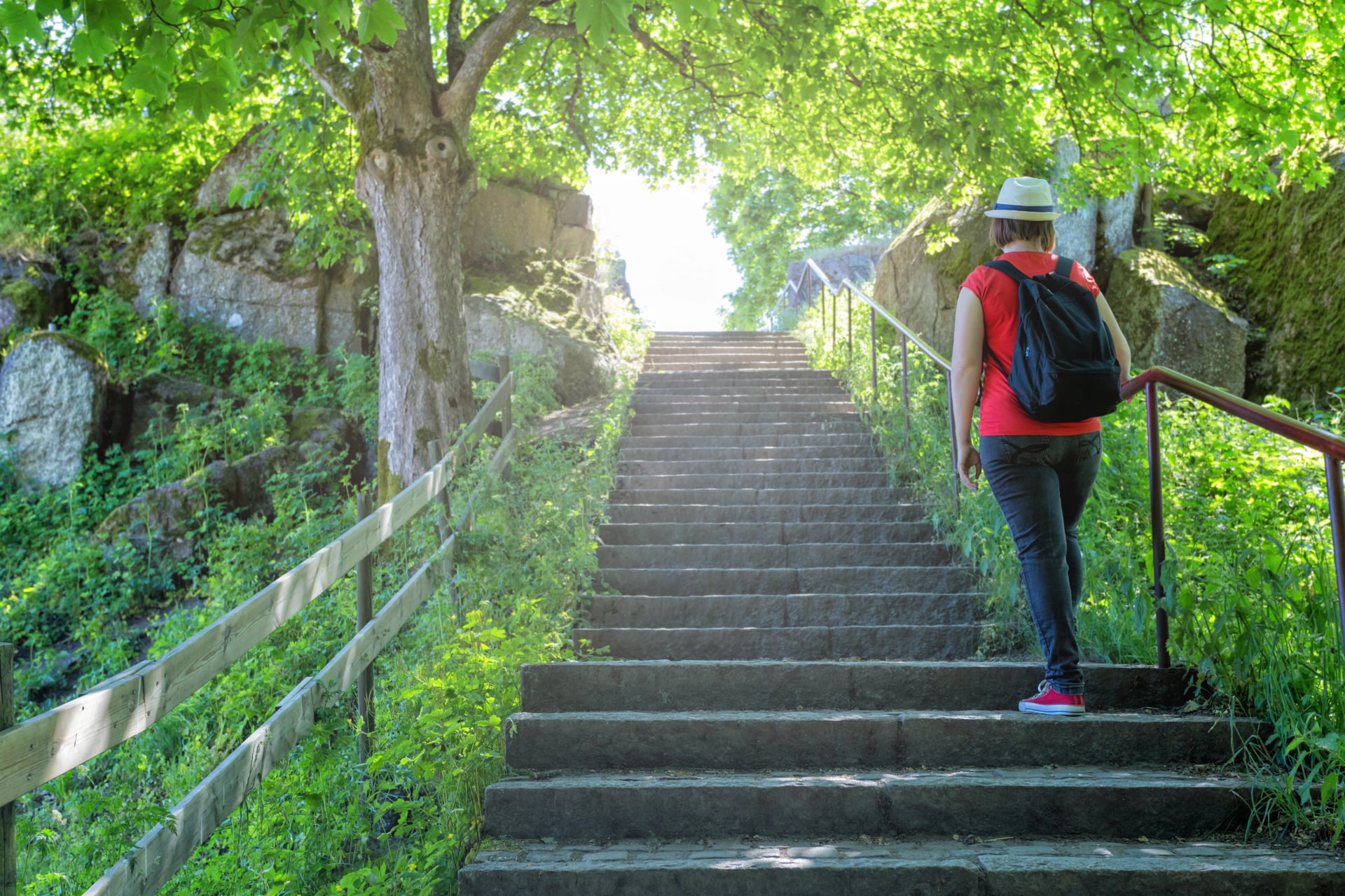 hiking woman climbing the stone stairs to peak
