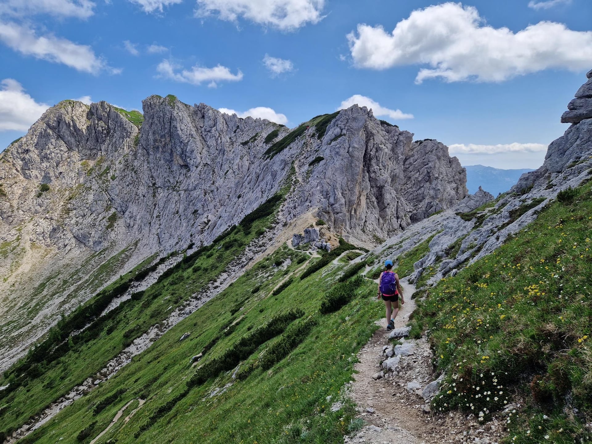 Randonneur avec un sac à dos marchant sur un sentier à travers les pics de calcaire dentelés du Mont Triglav dans les Alpes juliennes.