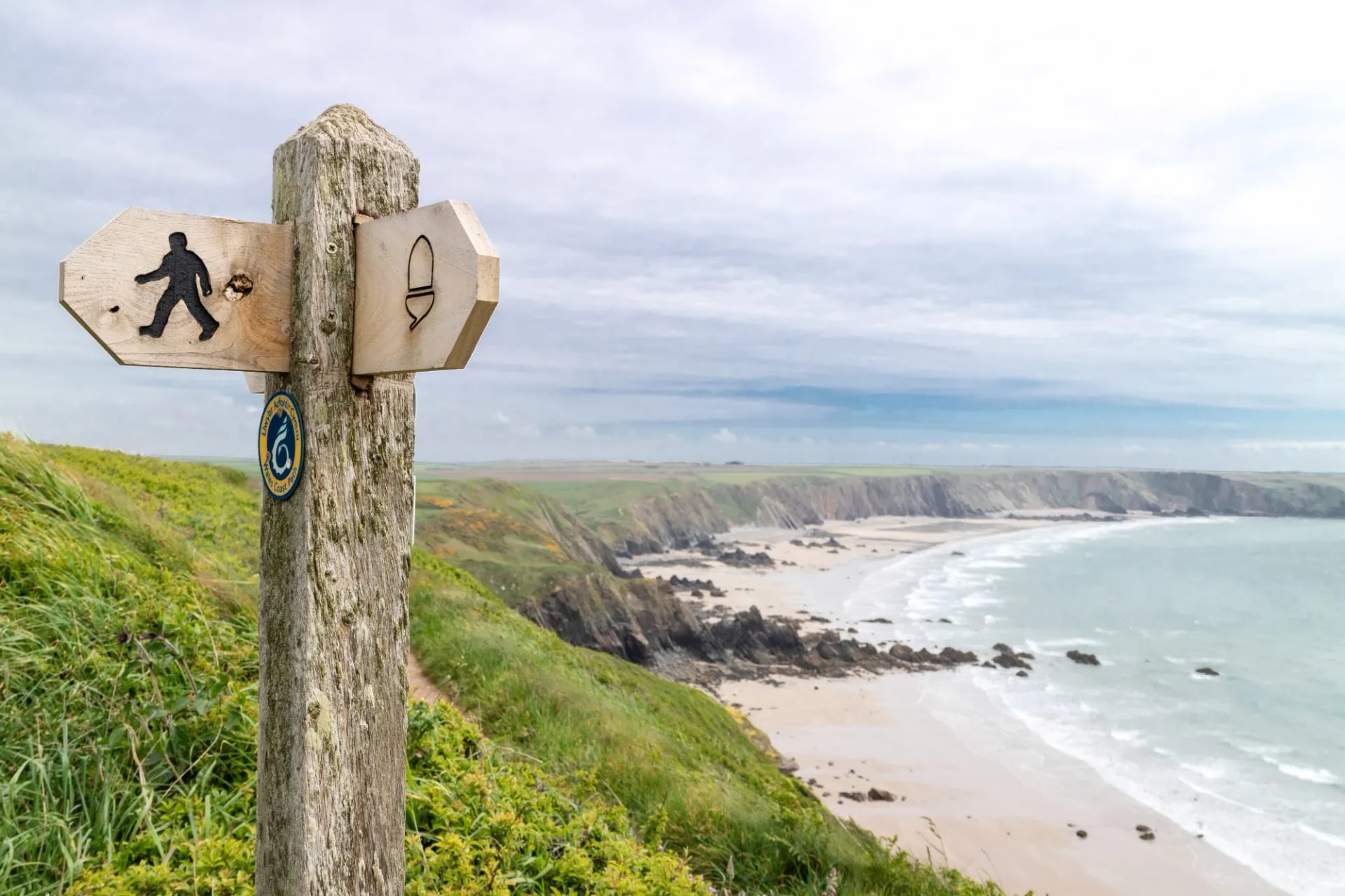 A wooden coast path fingerpost on the cliffs of the Pembrokeshire coast