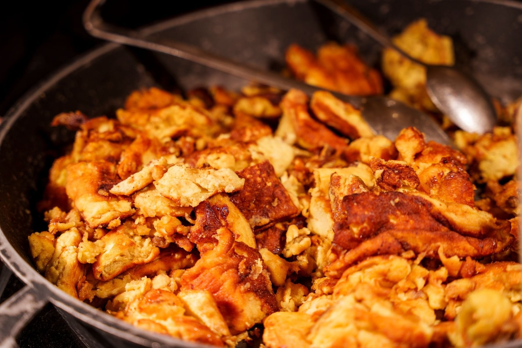 Kaiserschmarrn cooking in a cast iron skillet