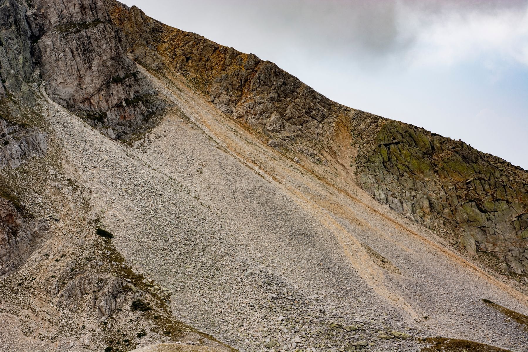 A bare scree slope of loose rock on a mountainside