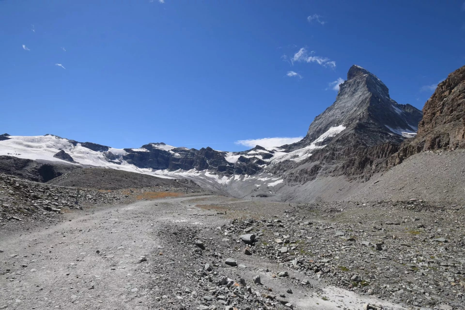 Kale stenige grond en oude door ijs geschuurde platen onder de oostwand van de Matterhorn