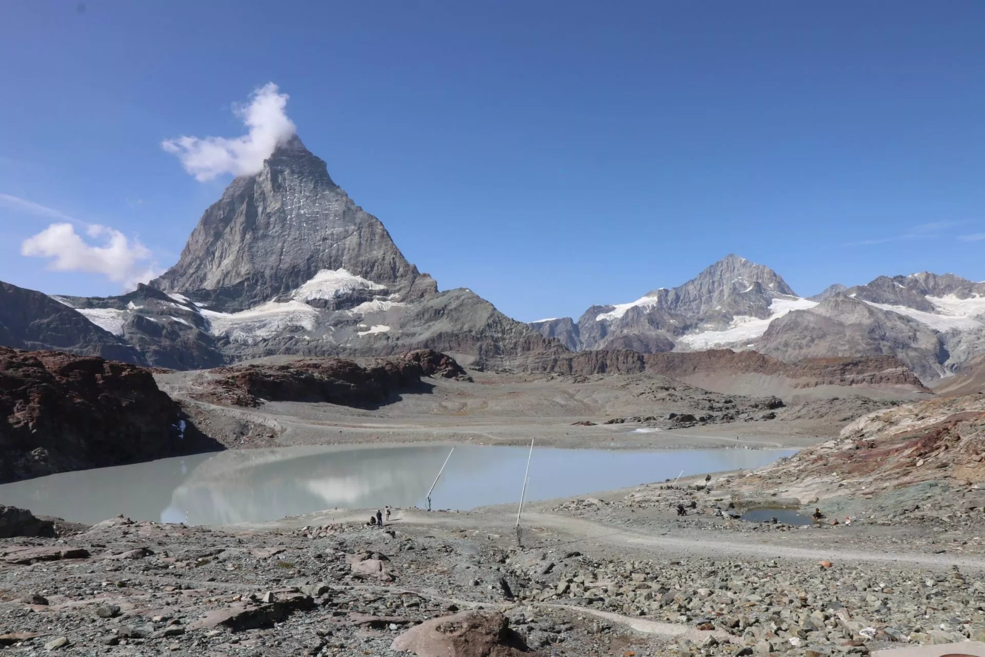 Een ondiepe poel op stenen grond met de Matterhorn die daarachter staat
