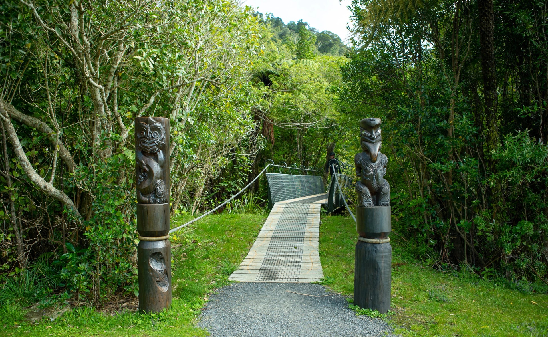 Carved pou and bridge at Ship Cove
