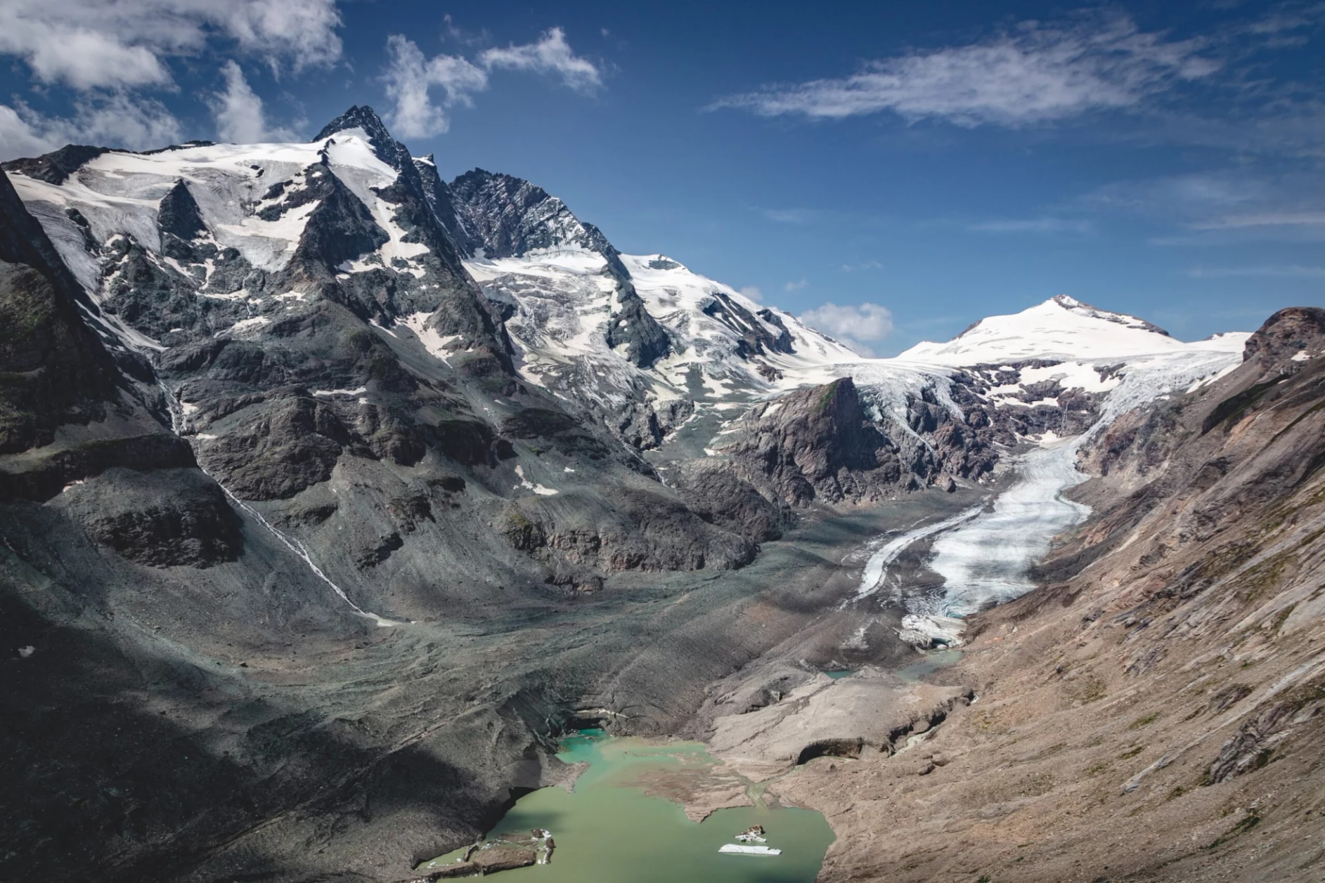 View of Grossglockner with glacier and turquoise meltwater lake from Kaiser-Franz-Josefs-Höhe.