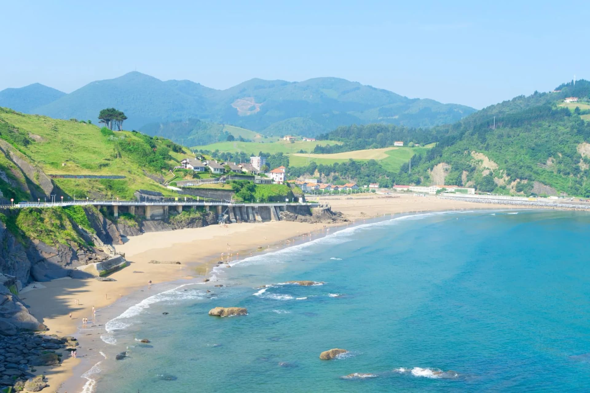 Cantabrian Sea coast and Deba town beach with green hills and blue water.