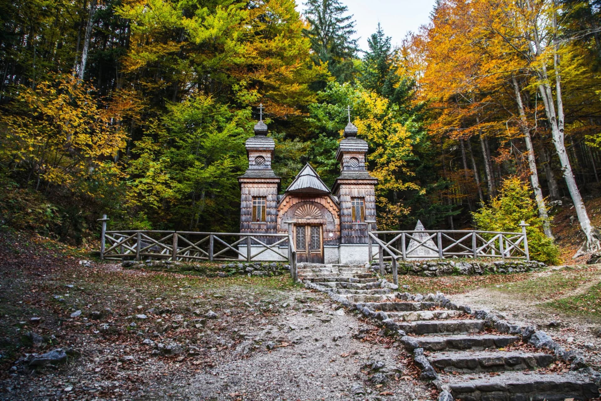 Russian Chapel in Triglav National Park with autumn foliage and stone steps.