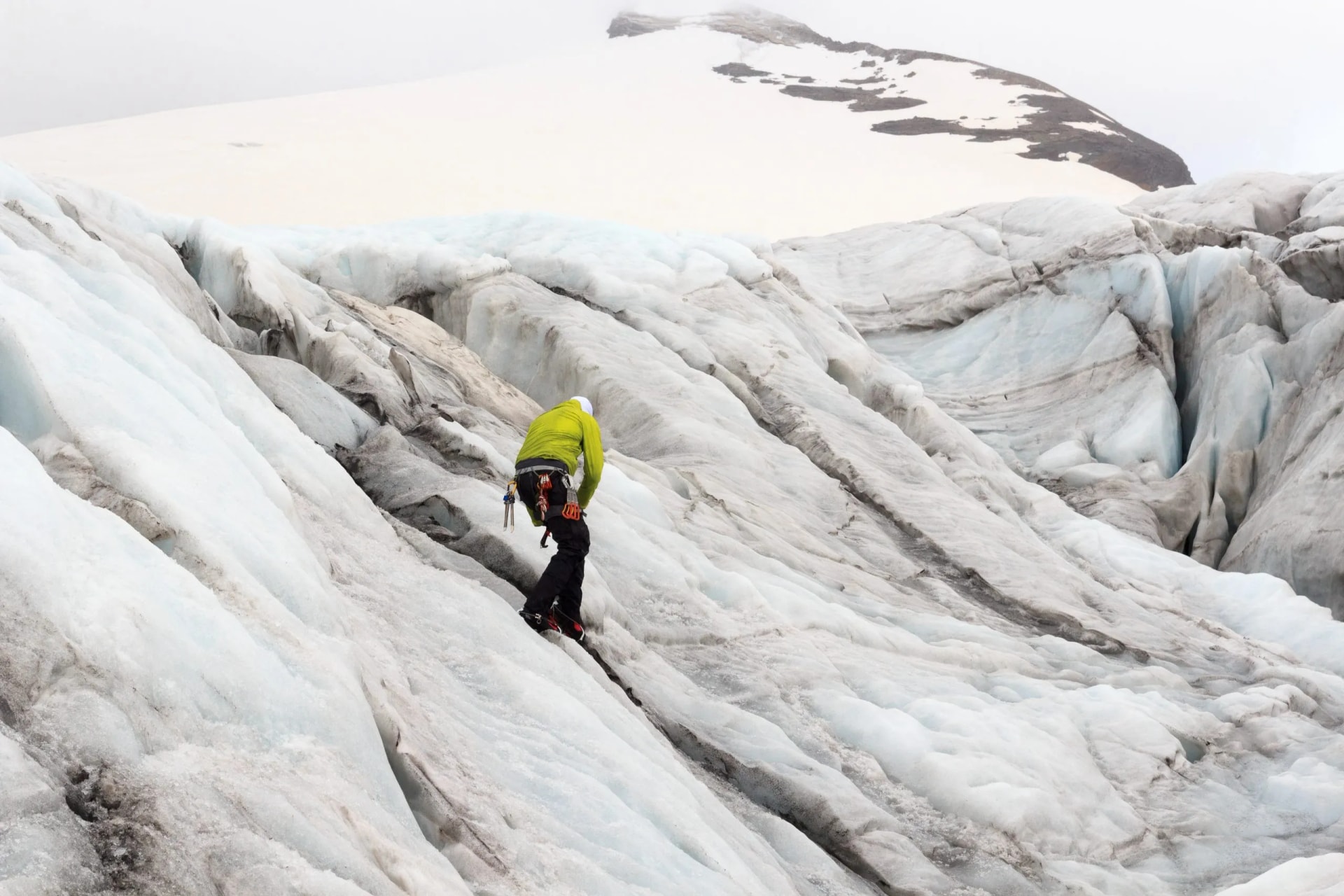 Mountaineer with crampons ascending Pasterze Glacier in the Glockner Group mountains.
