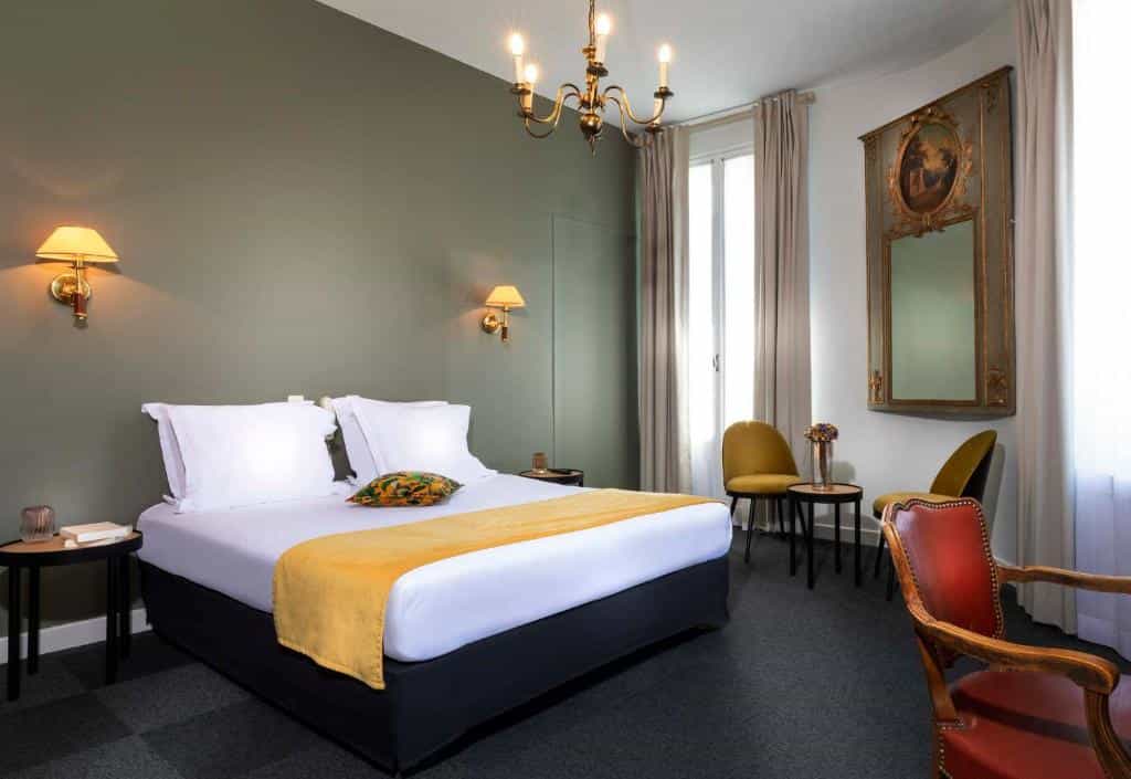 Bedroom in Hotel Saint Regis with double bed, brass chandelier, and antique mirror.