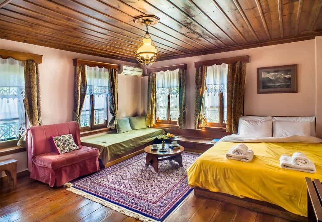 Cozy hotel room with wooden ceiling, yellow bed, and window seating area