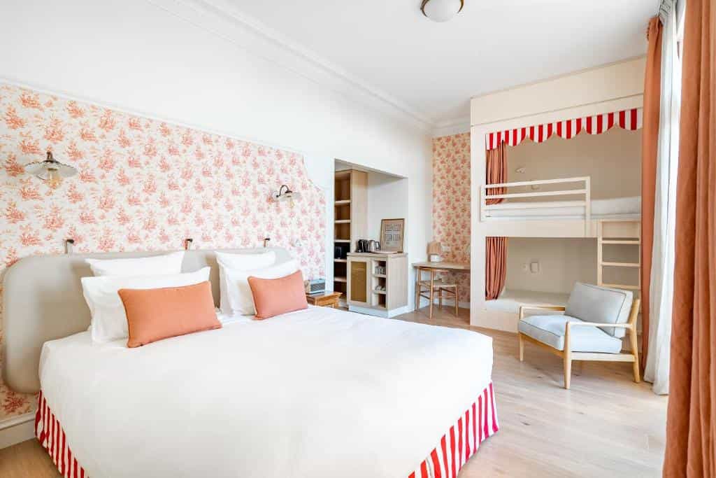 Hotel room with double bed, built-in bunk beds, and pink floral wallpaper at Villa Camille Hotel & Spa.