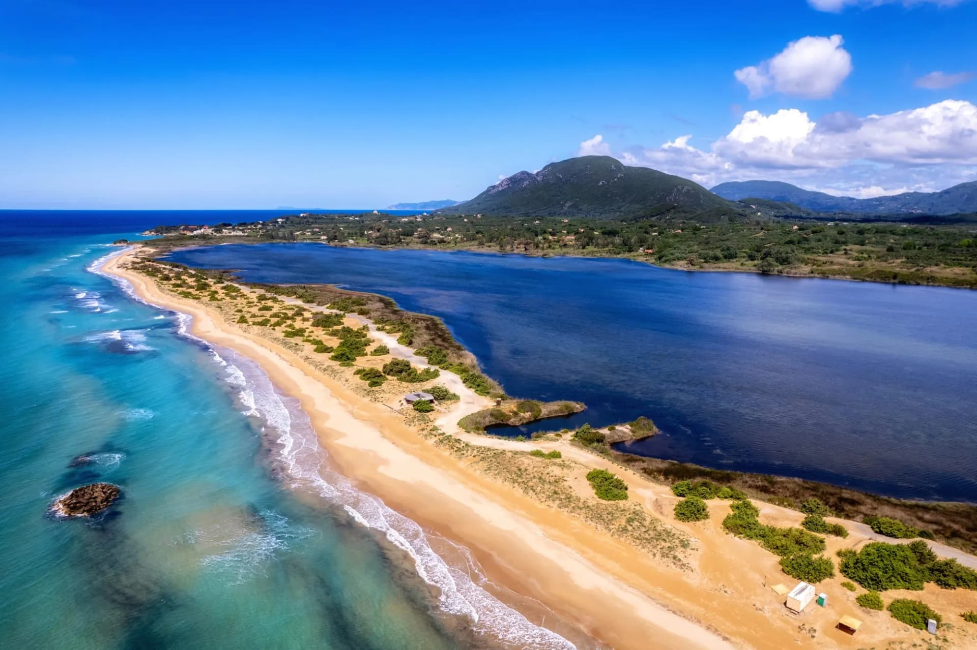 Langer Sandstrand mit dahinter liegendem See Korission Lagoon an der Westküste von Korfu