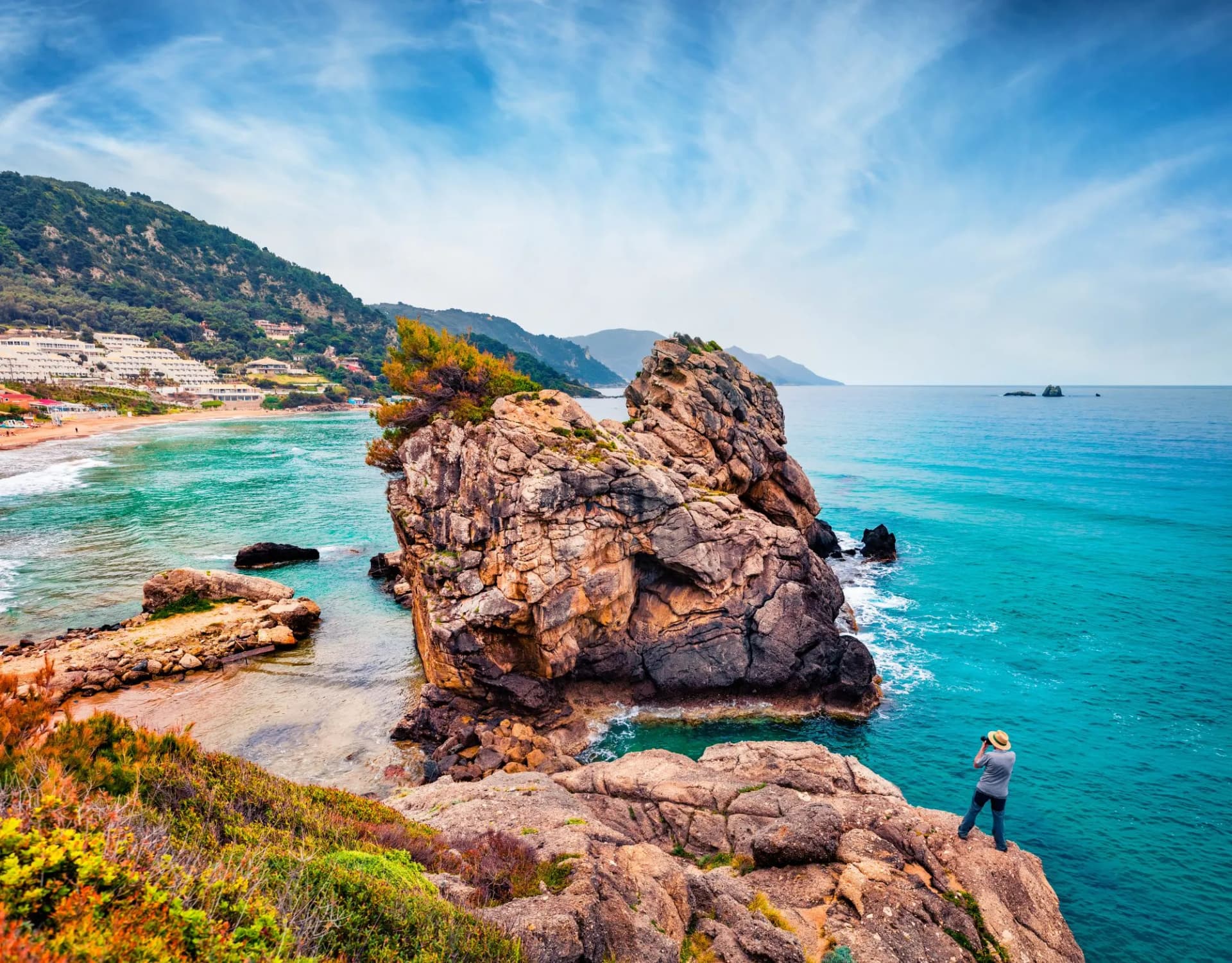 Photographer takes picture of huge cliff and Pelekas beach on background. Exciting morning seascape of Ionian Sea, Corfu island, Kontogialos health resort, Greece, Europe.