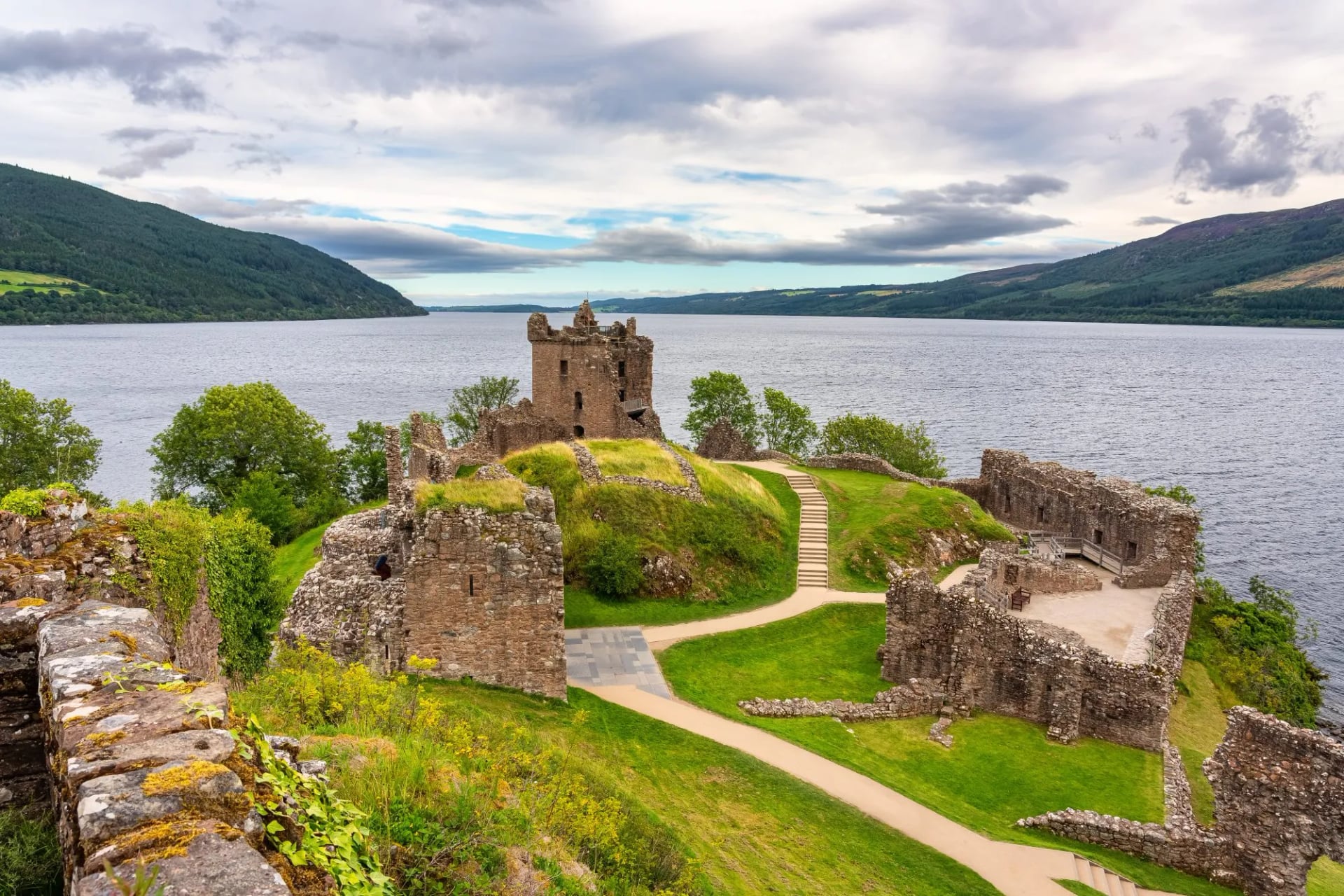 The ruins of Urquhart Castle on a green promontory beside Loch Ness