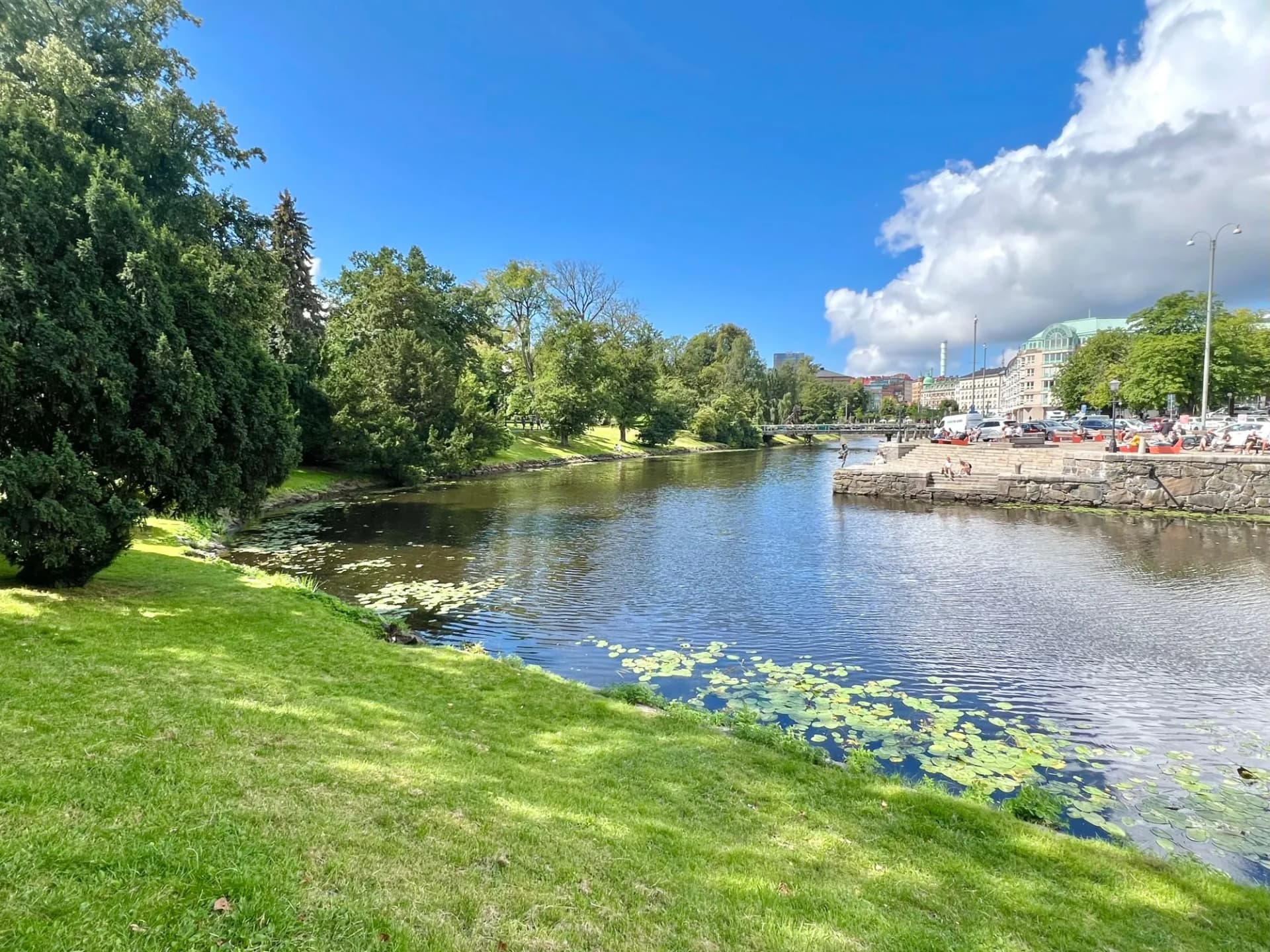 Beautiful cityscape of a river with water lilies and a picturesque park on a sunny day in Gothenburg, Sweden