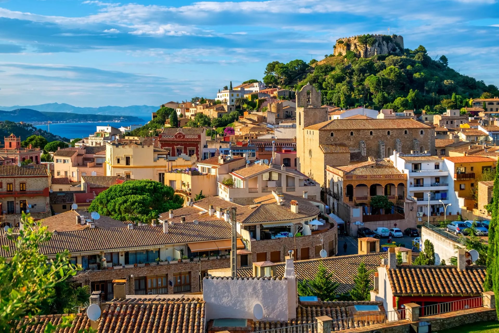 Terracotta roofs of Begur climbing towards the castle ruins on the hilltop above