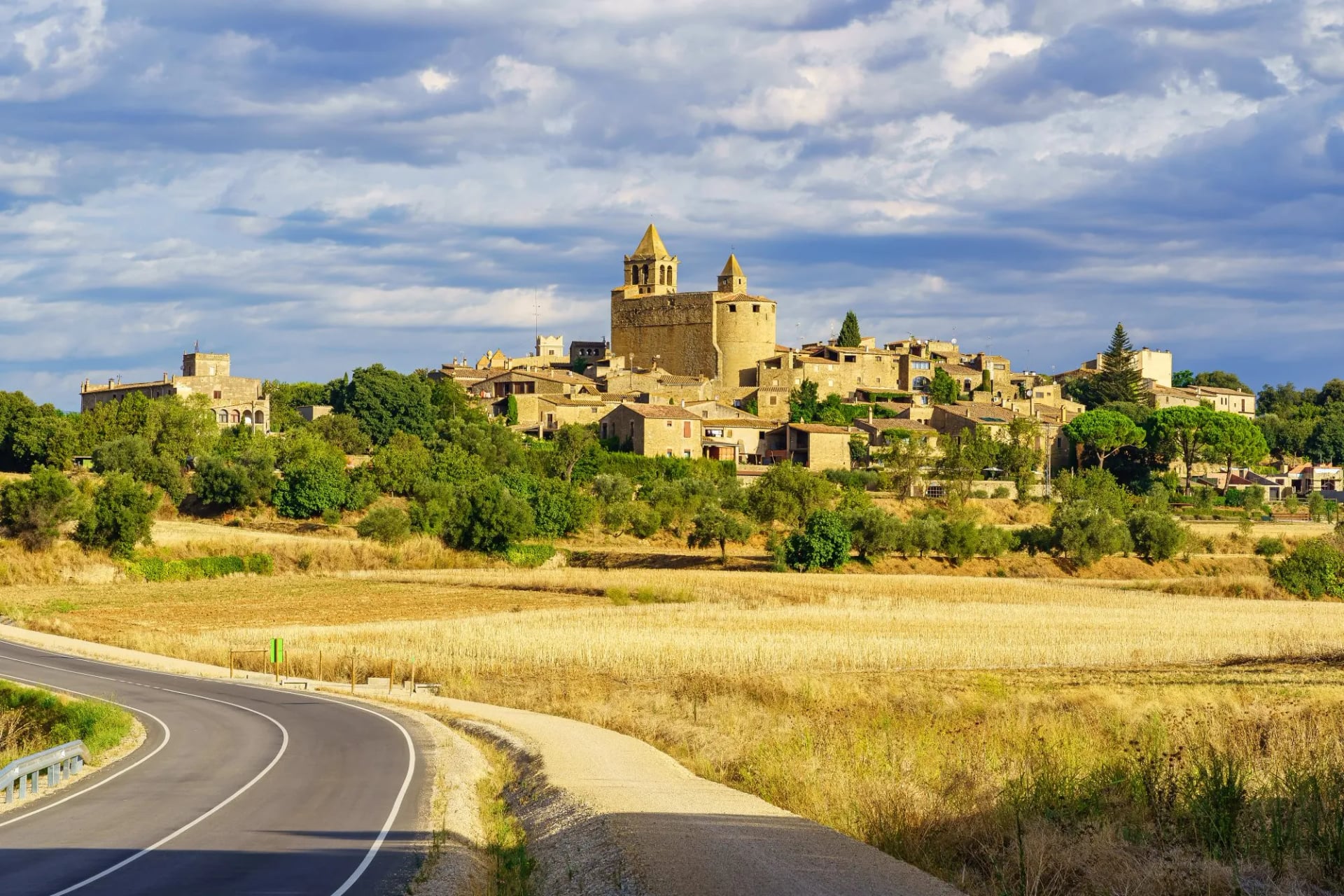 Hilltop village of Madremanya above dry summer fields in the Empordà