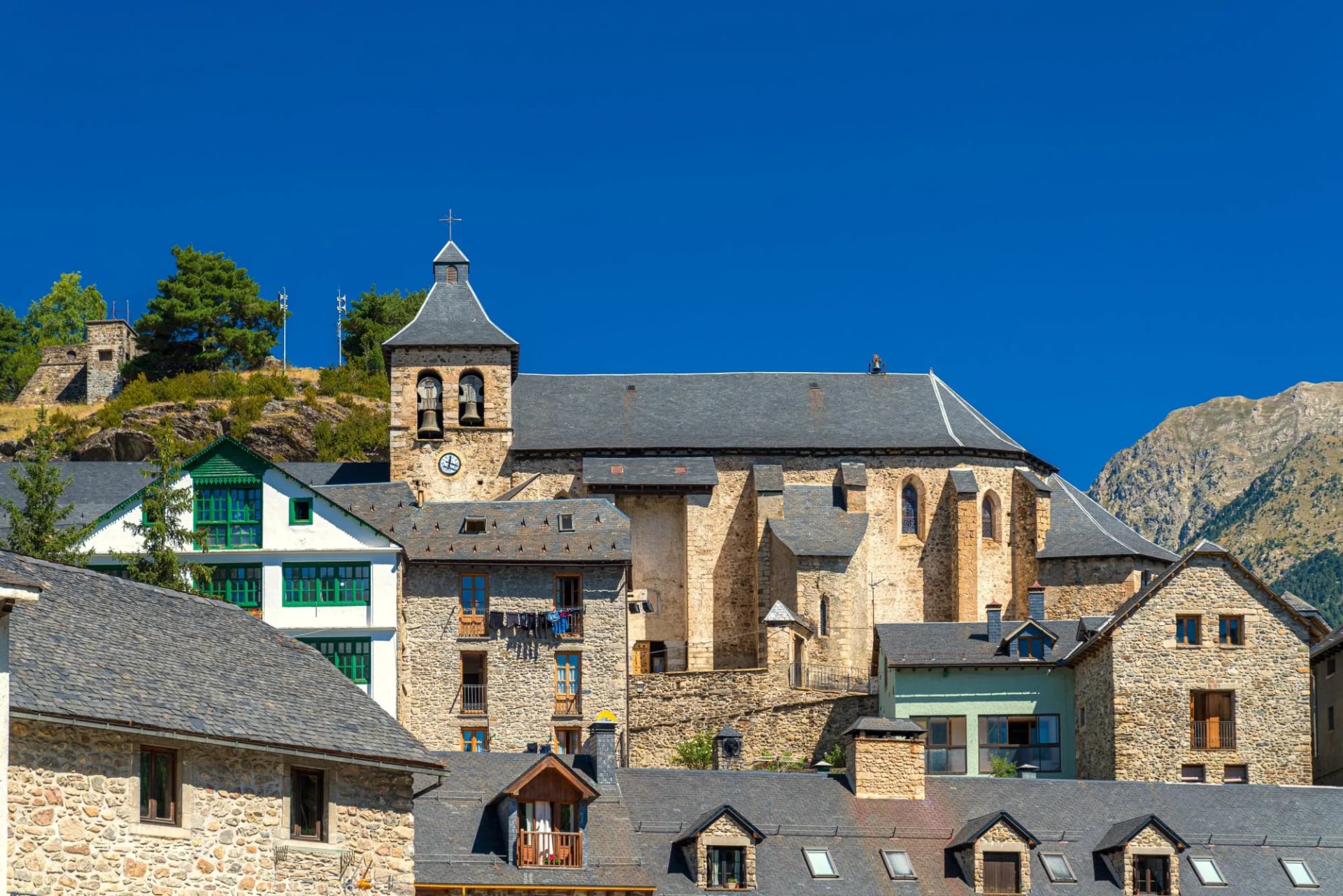 Stone houses and a church tower in the mountain village of Sallent de Gállego