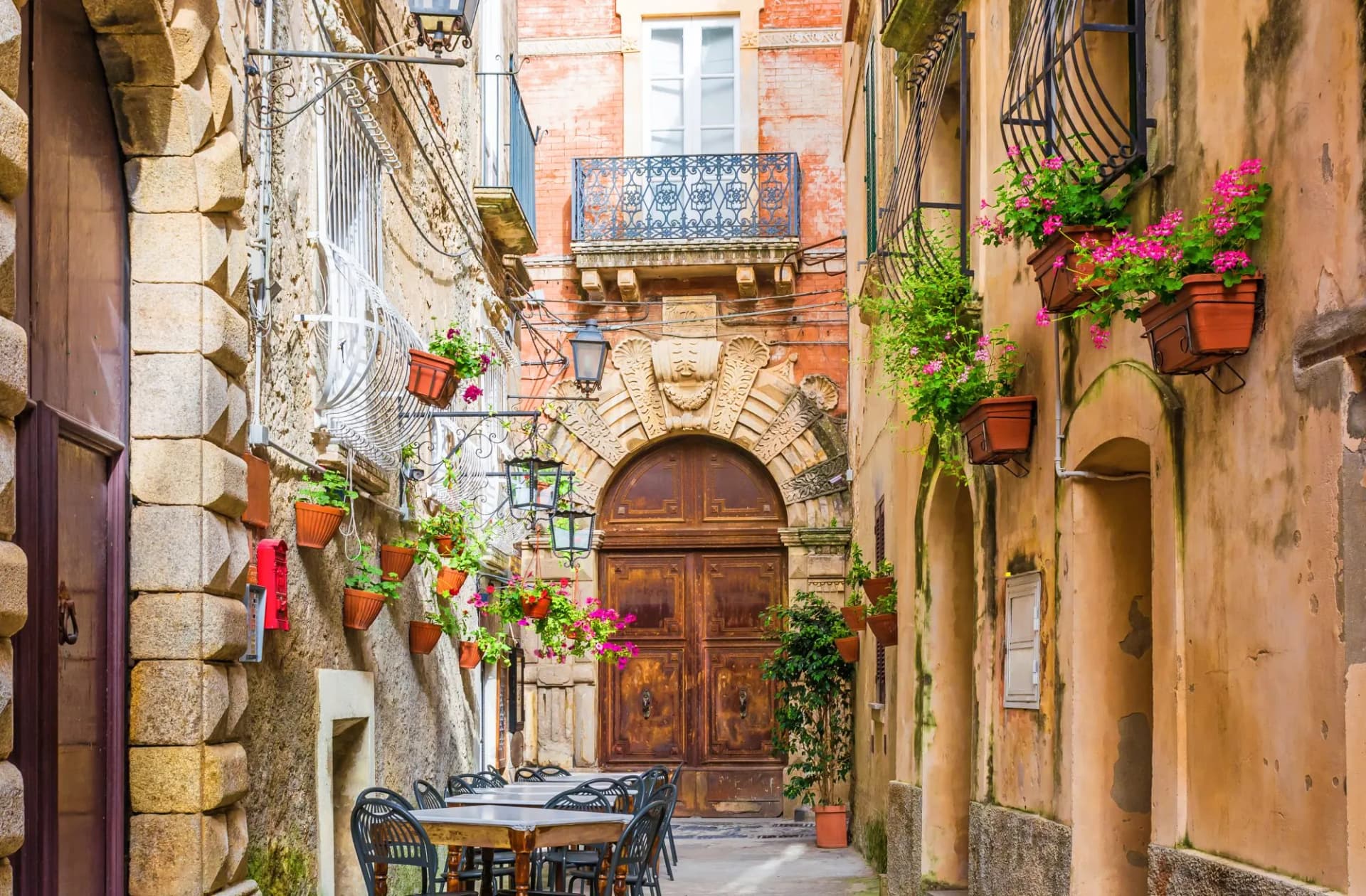 Cafe tables and chairs outside in old cozy street in the Positano town, Italy