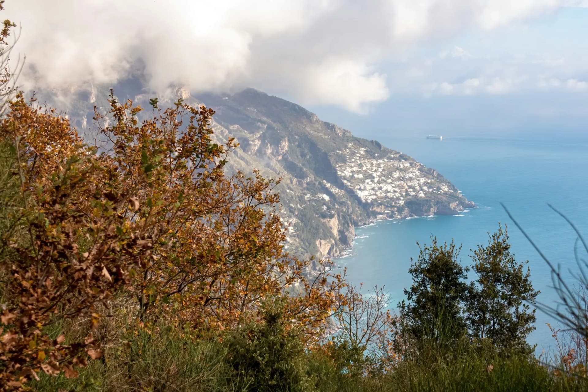 Panoramic view from hiking trail leading to the coastal town of Positano appearing from the clouds. Hiking in Lattari Mountains, Apennines, Amalfi Coast, Campania, Italy, Europe. Mediterranean Sea