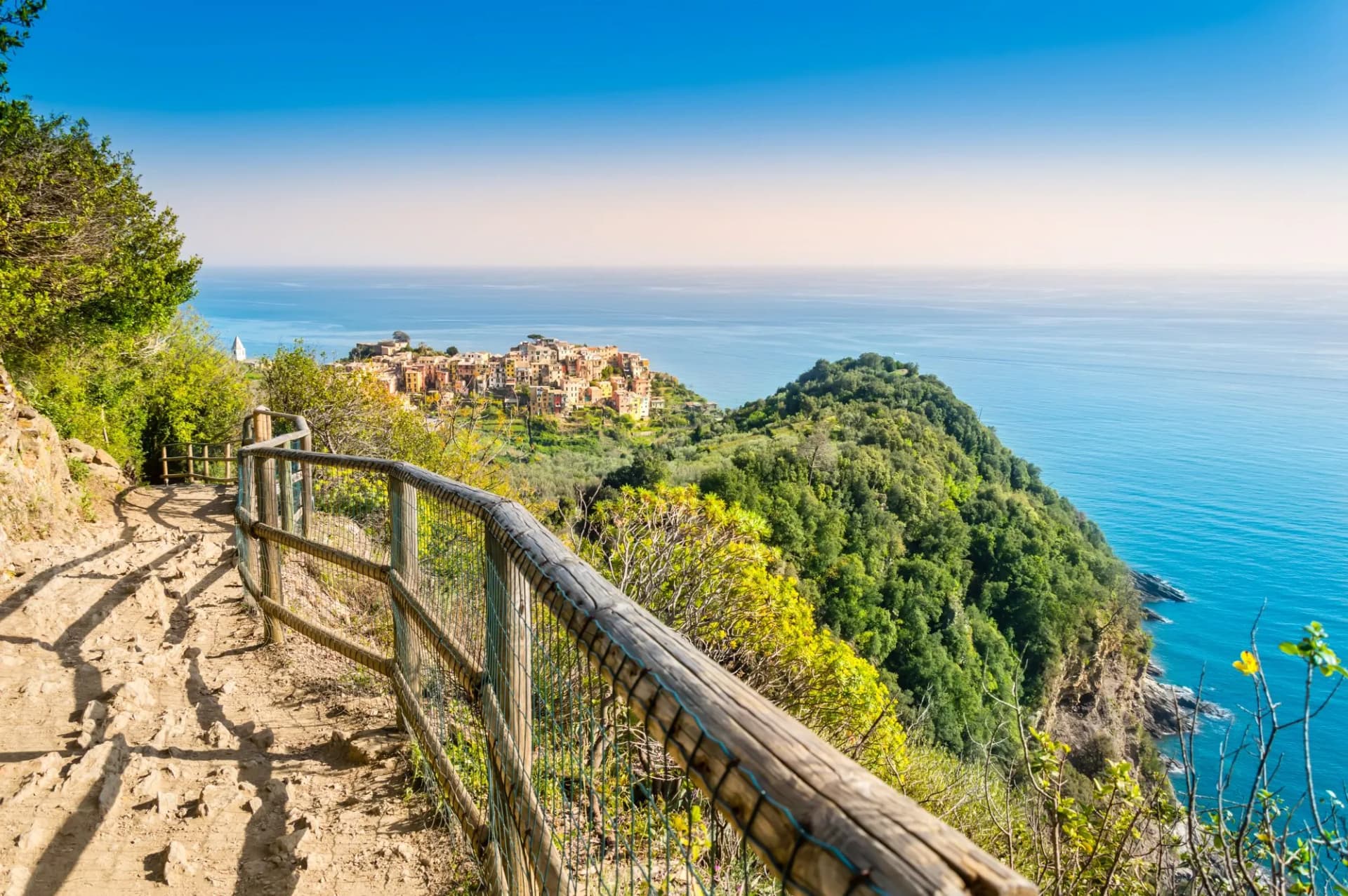 Corniglia, Cinque Terre - hiking trail near beautiful village with colorful buildings on the cliff over sea. Cinque Terre National Park with rugged coastline is famous tourist destination in Italy