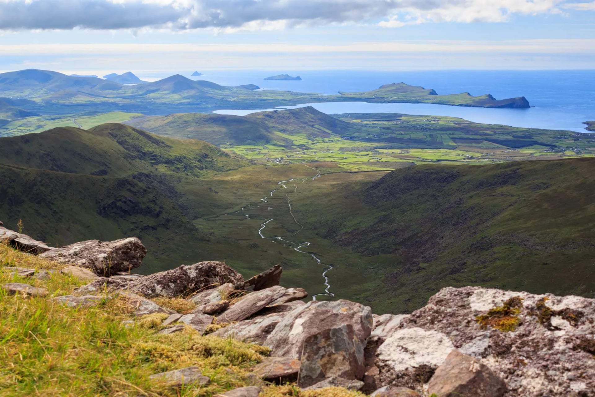Een pad dat door een groene vallei naar de Atlantische Oceaan daalt op het Dingle-schiereiland