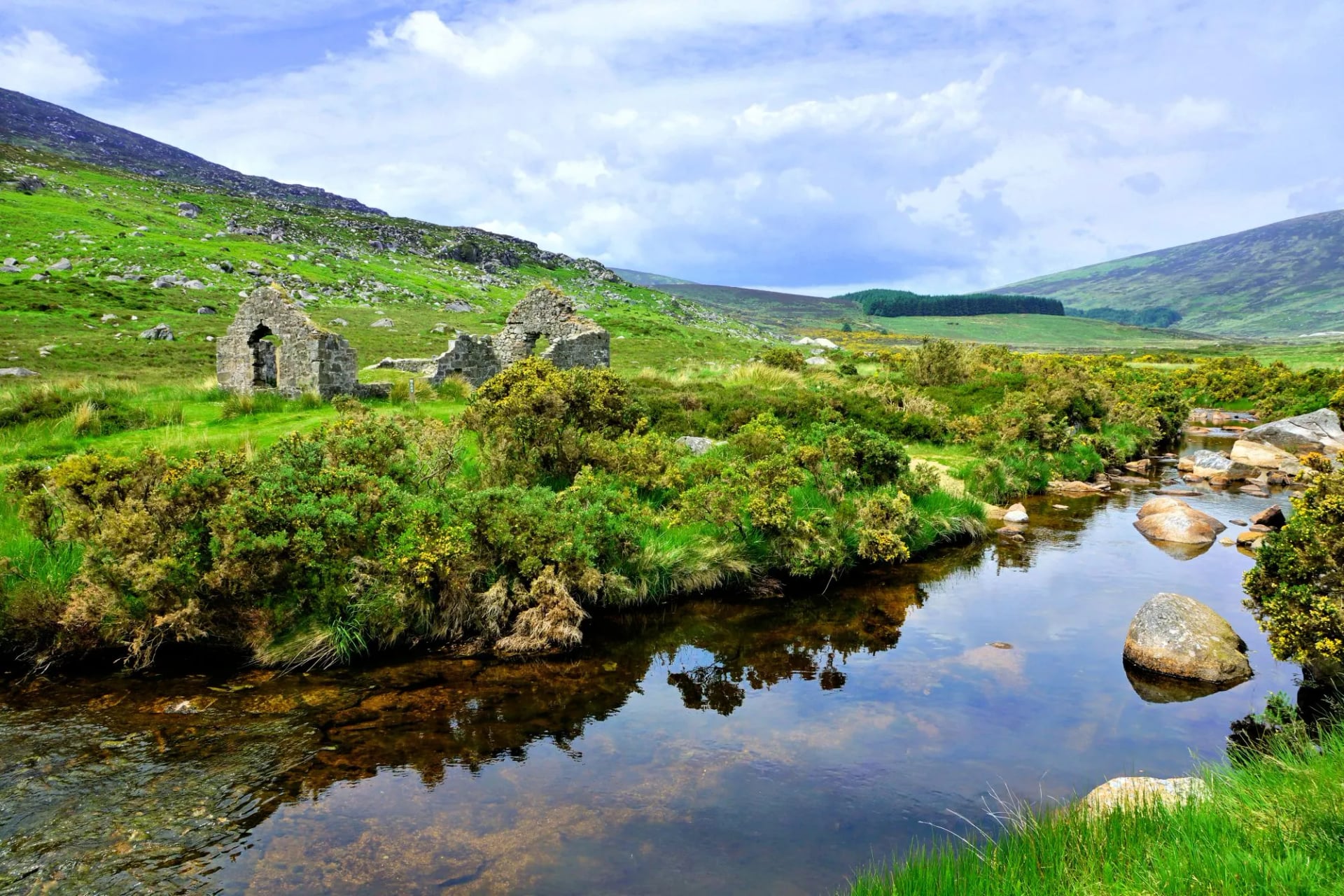 Een vervallen mijngebouw naast een beek in de Wicklow Mountains