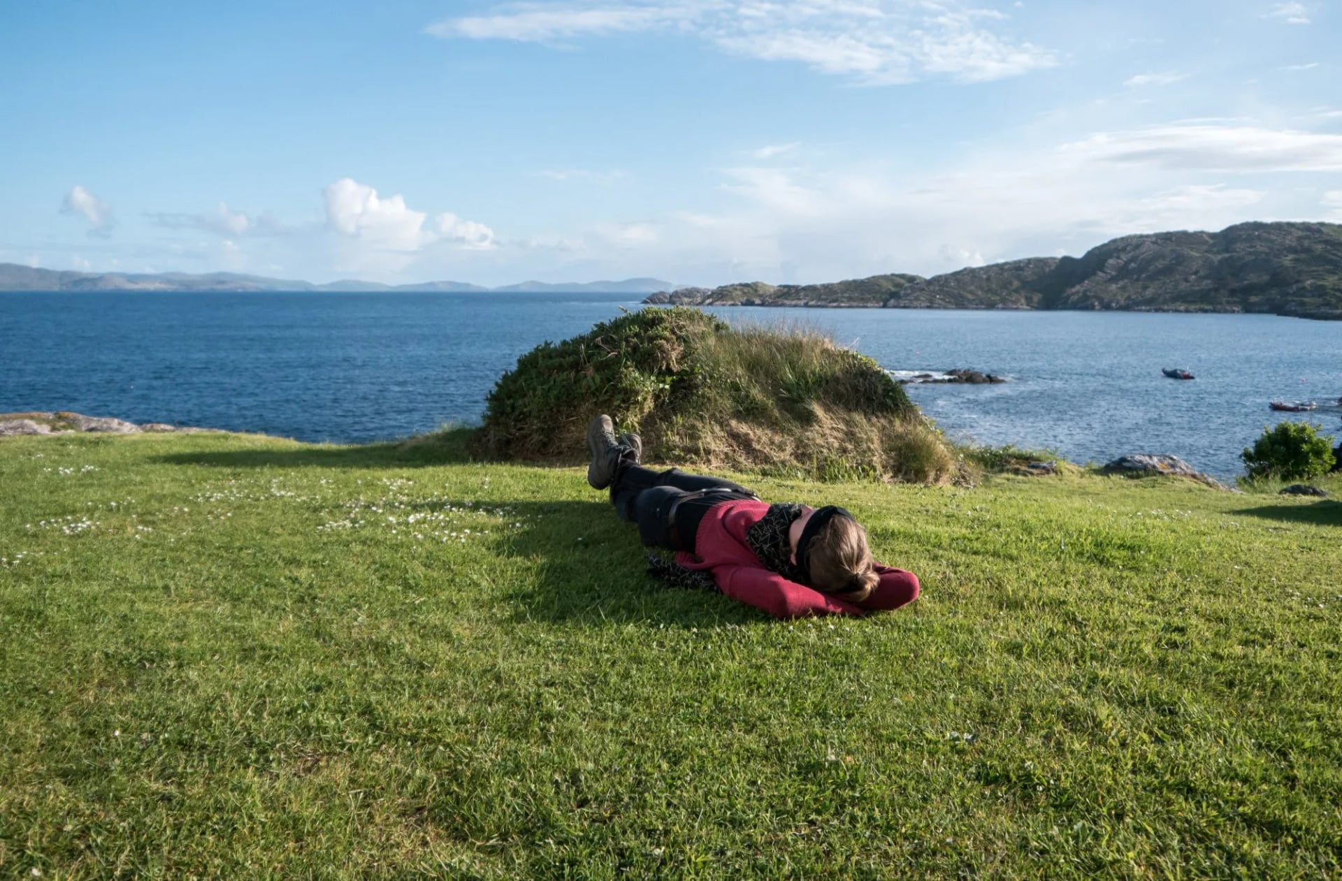 Een wandelaar rustend aan de kust bij Caherdaniel in County Kerry