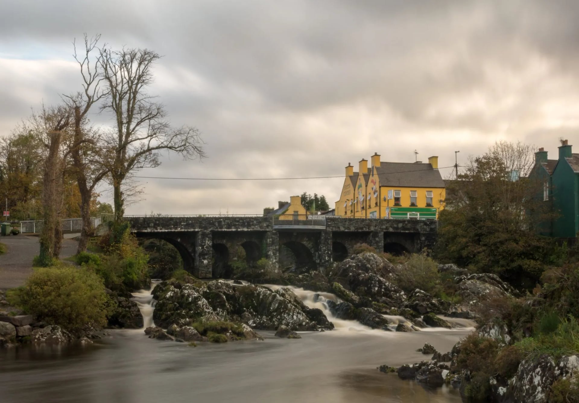De brug en rivier bij het dorp Sneem onder zware herfstbewolking
