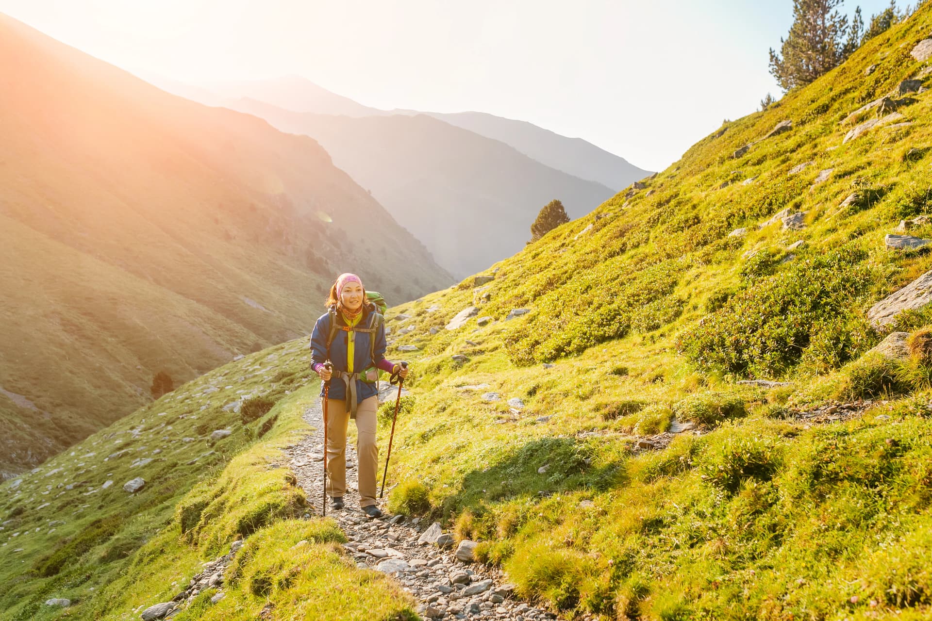 Happy woman walking with backpack in Pyrenees mountains Highlands