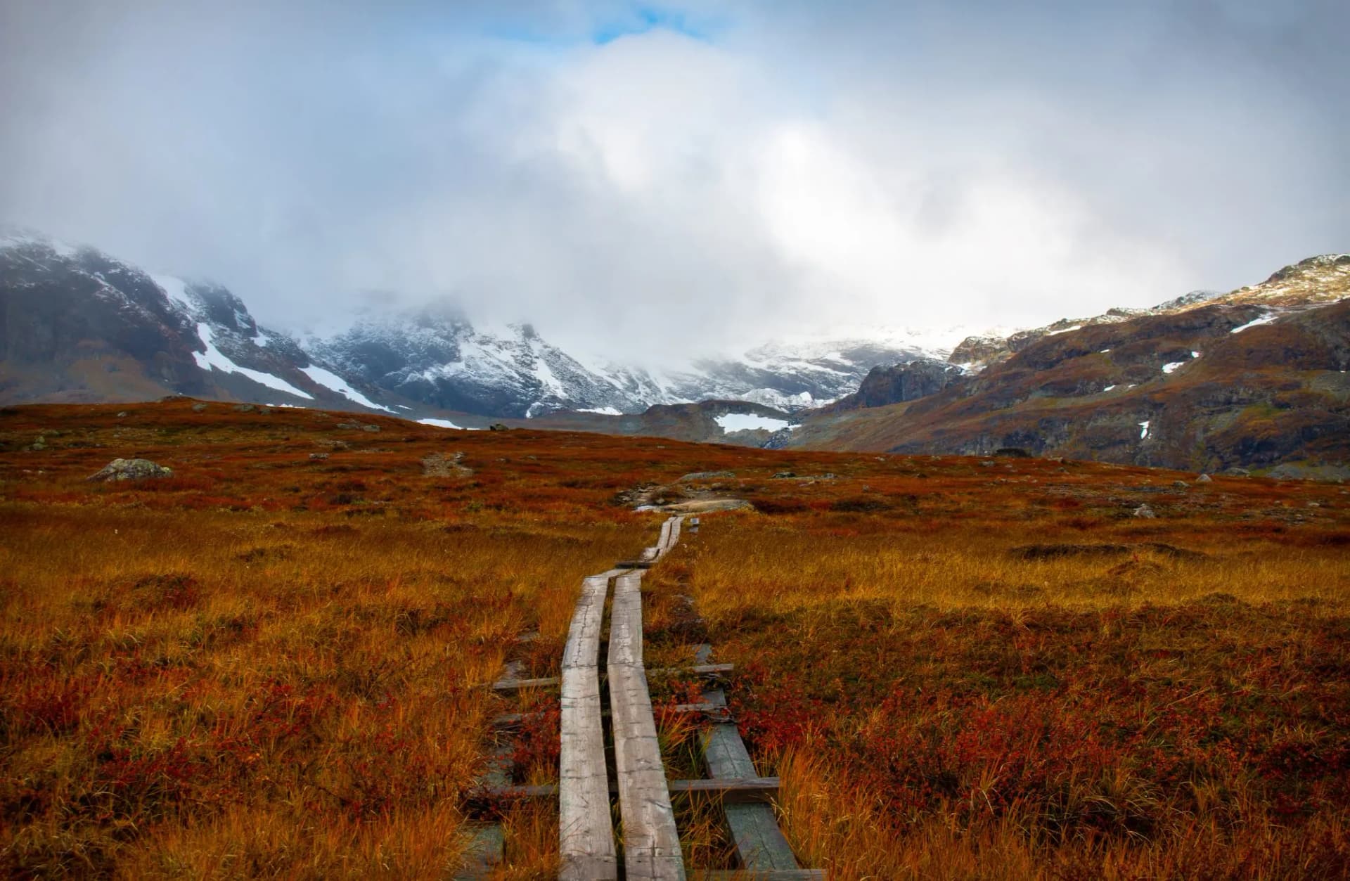 Swampy parts of Kungsleden trail with a wooden path, hiking in September, Lapland, Sweden