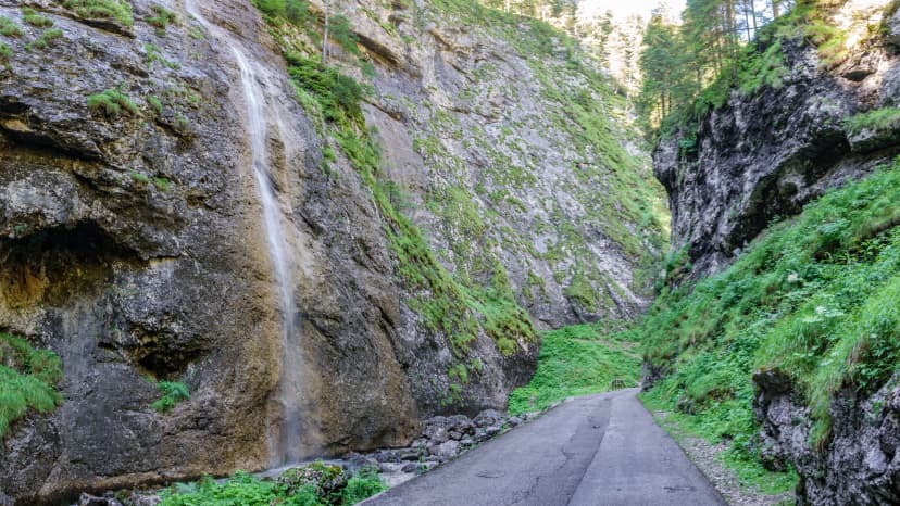 Road across Serrai di Sottoguda gorge with waterfall, Marmolada
