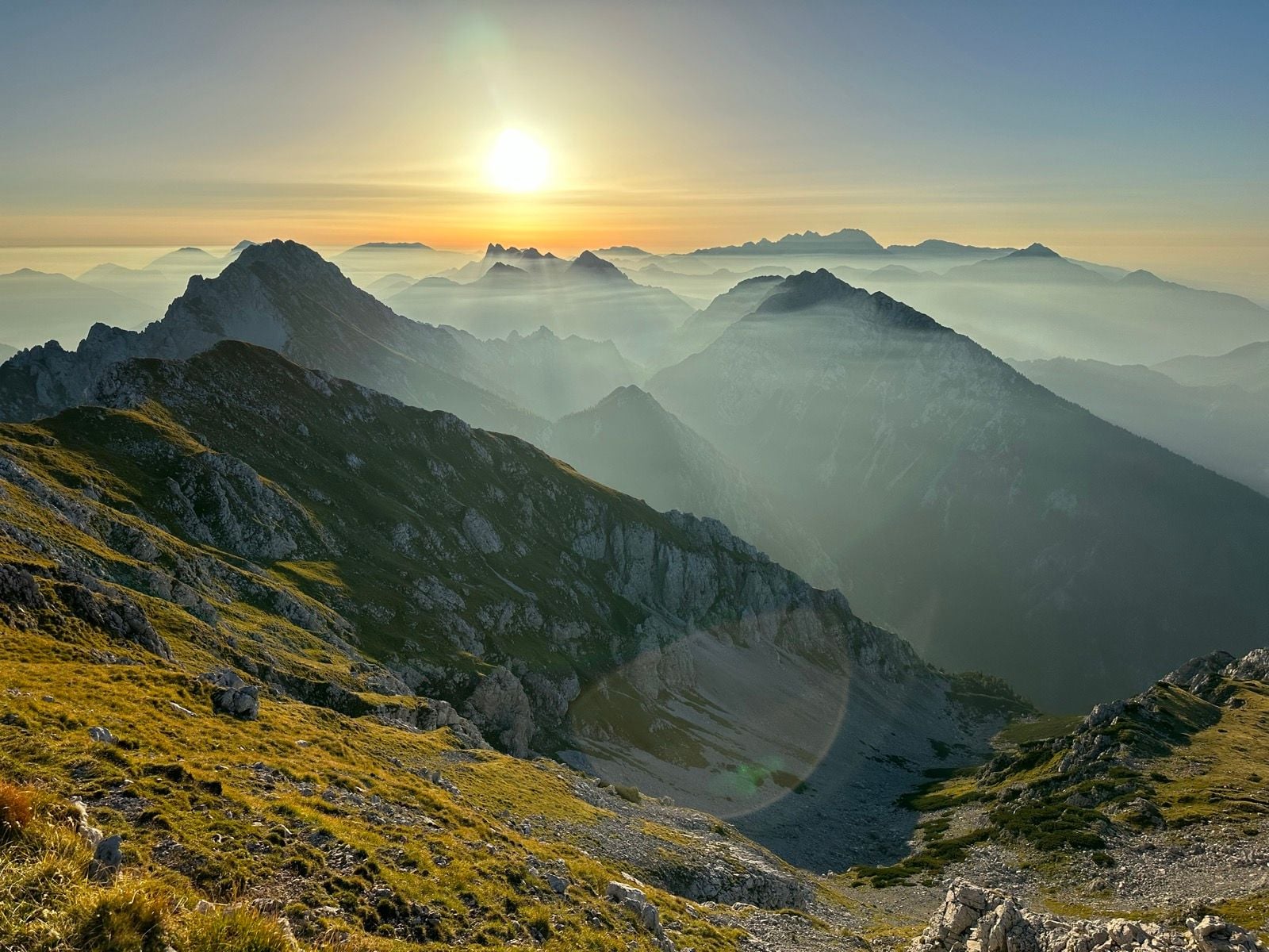Sunset over the Zelenica mountain range with rugged peaks and misty valleys.