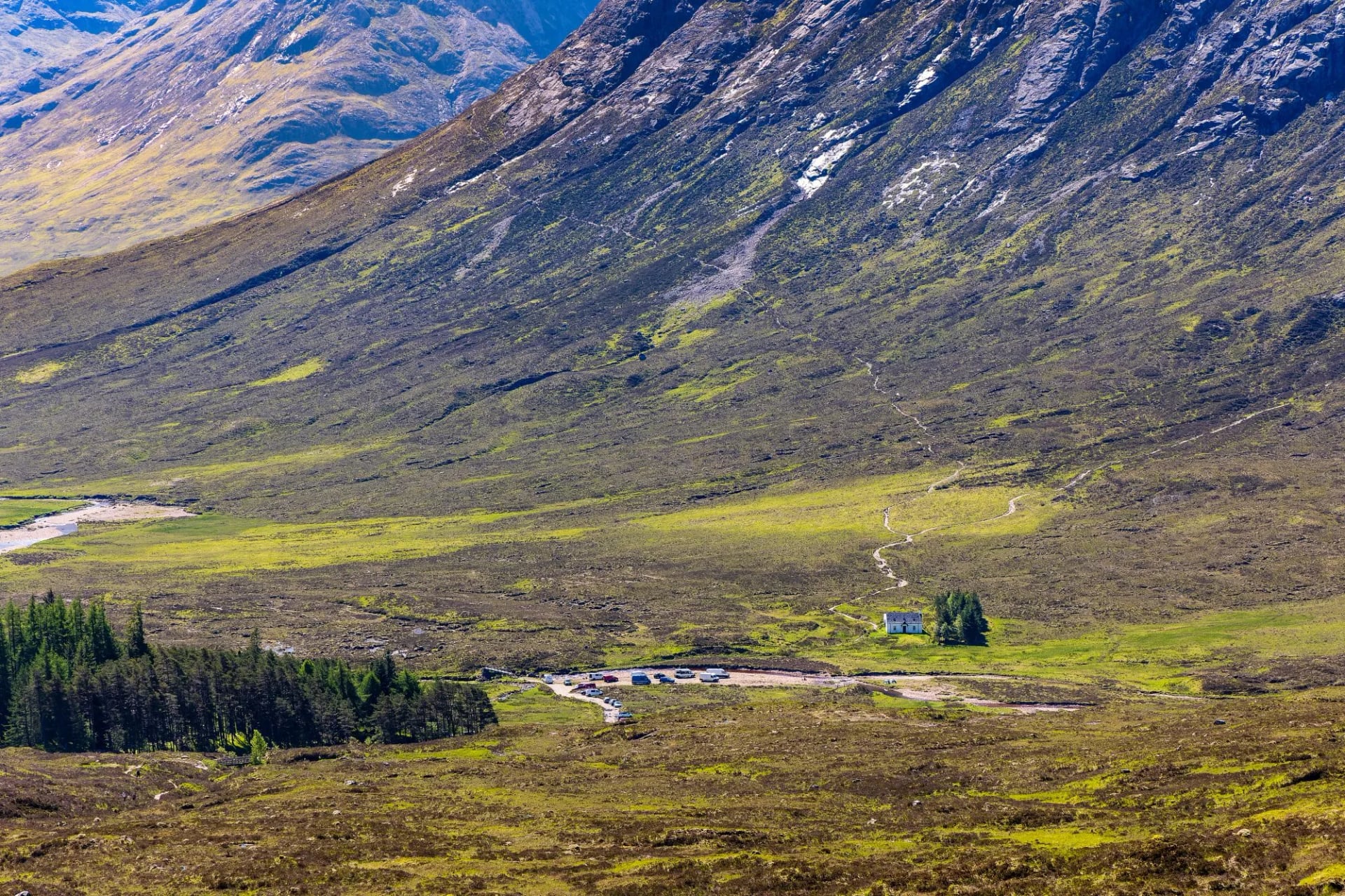The steep flank of a Glen Coe mountain above the valley floor and its road
