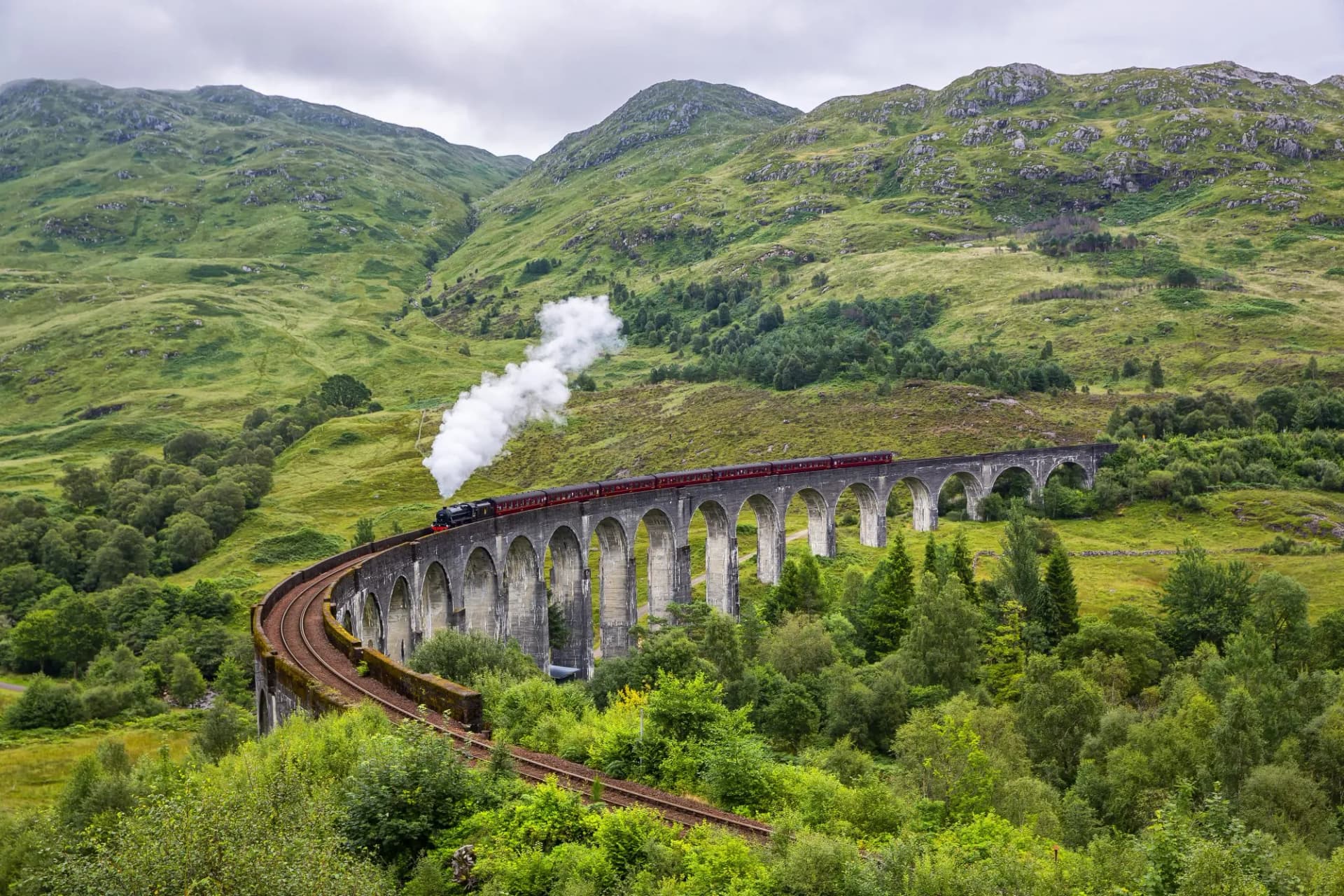 Glenfinnan railway viaduct in Scotland with the Jacobite steam train passing by