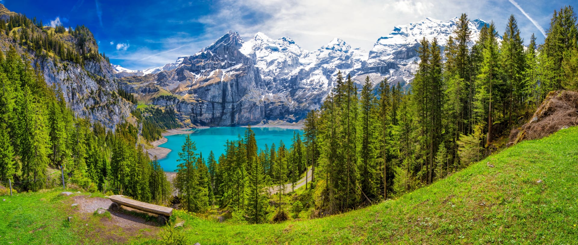 Úžasné tyrkysové jezero Oeschinnensee s vodopády, dřevěnou chatou a švýcarskými Alpami, Berner Oberland, Švýcarsko