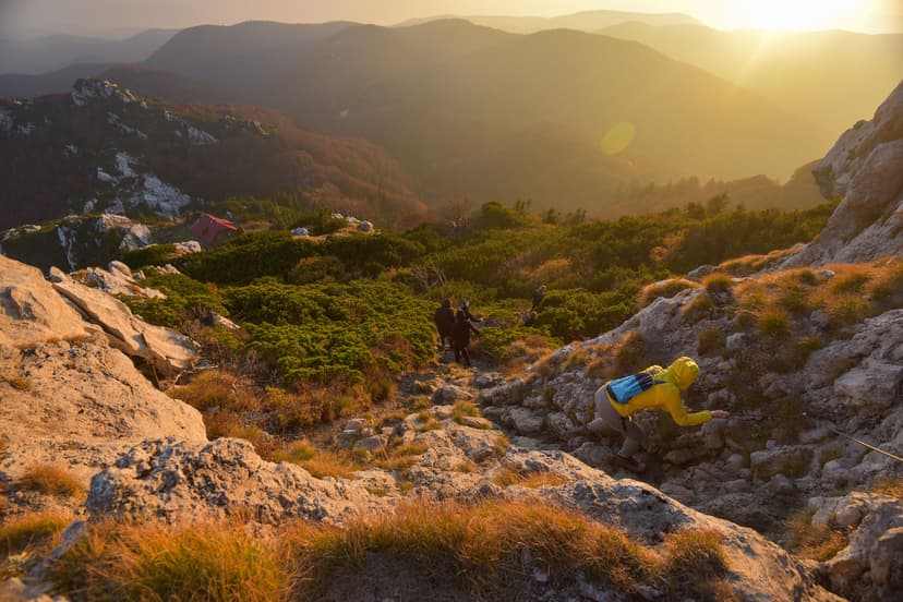 Hikers descending rocky mountain trail in Velebit during sunset