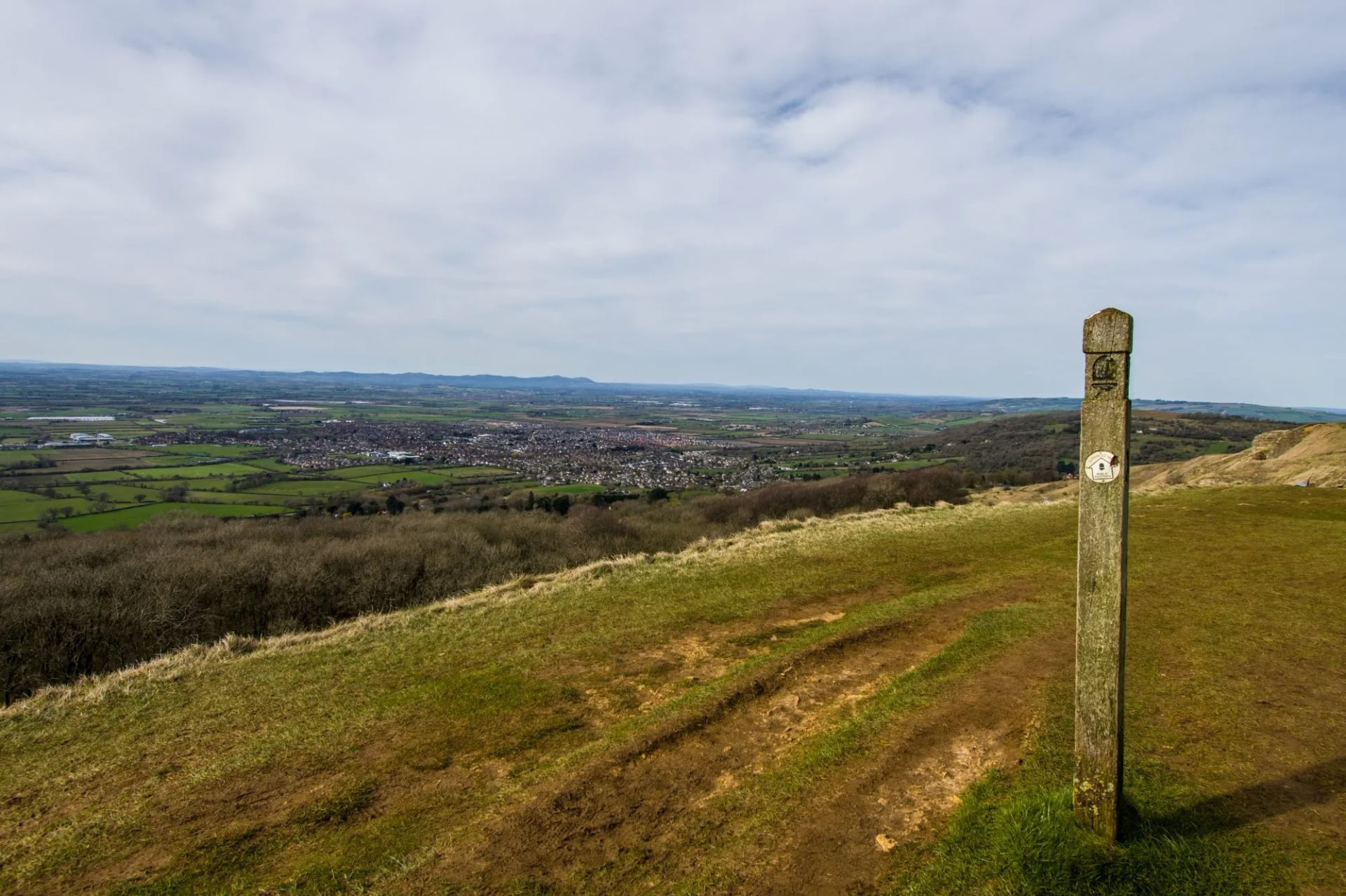Waymark post on the open grassland of Cleeve Hill above the vale