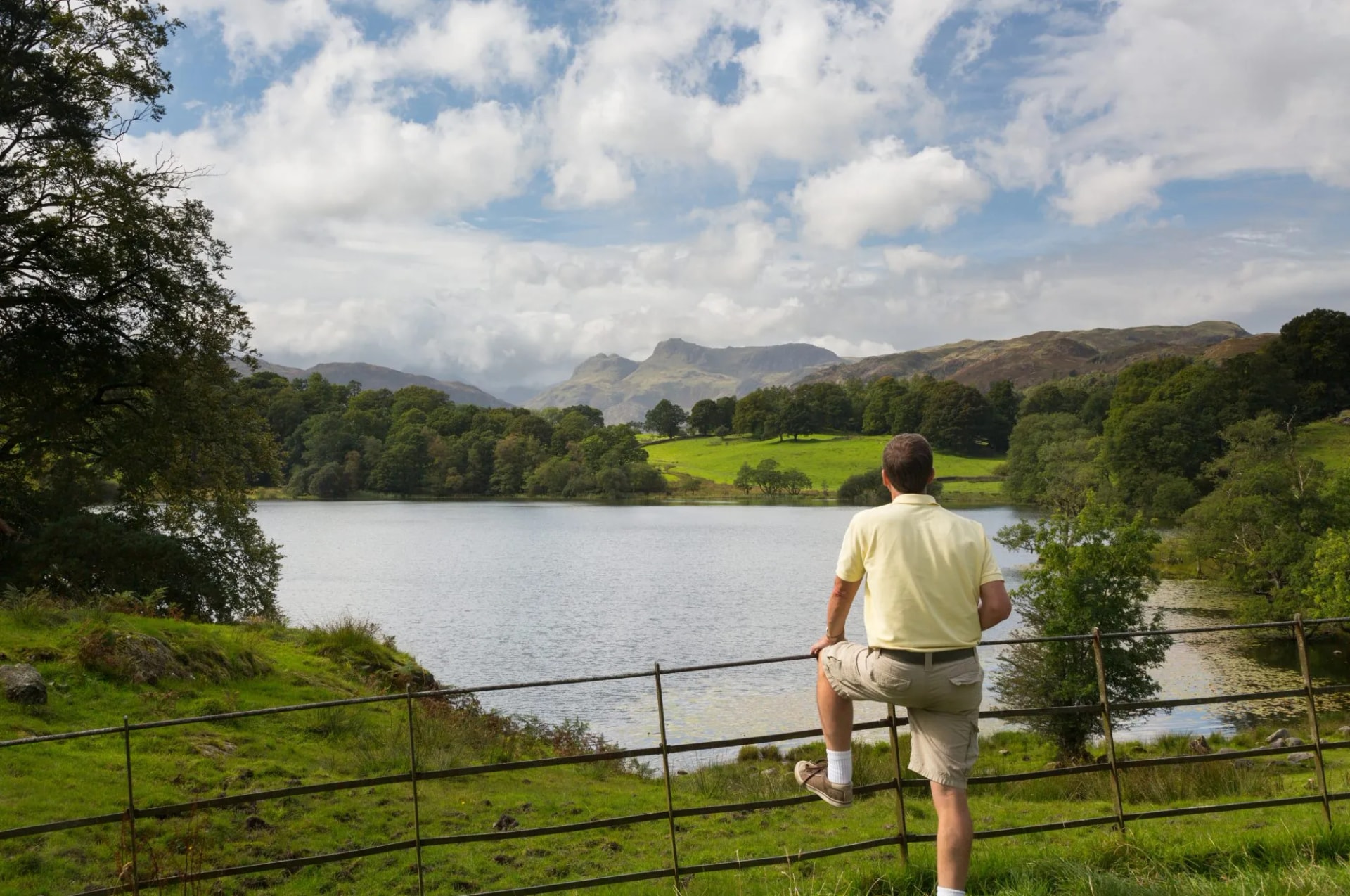 Hiker overlooks Loughrigg Tarn in Lake District