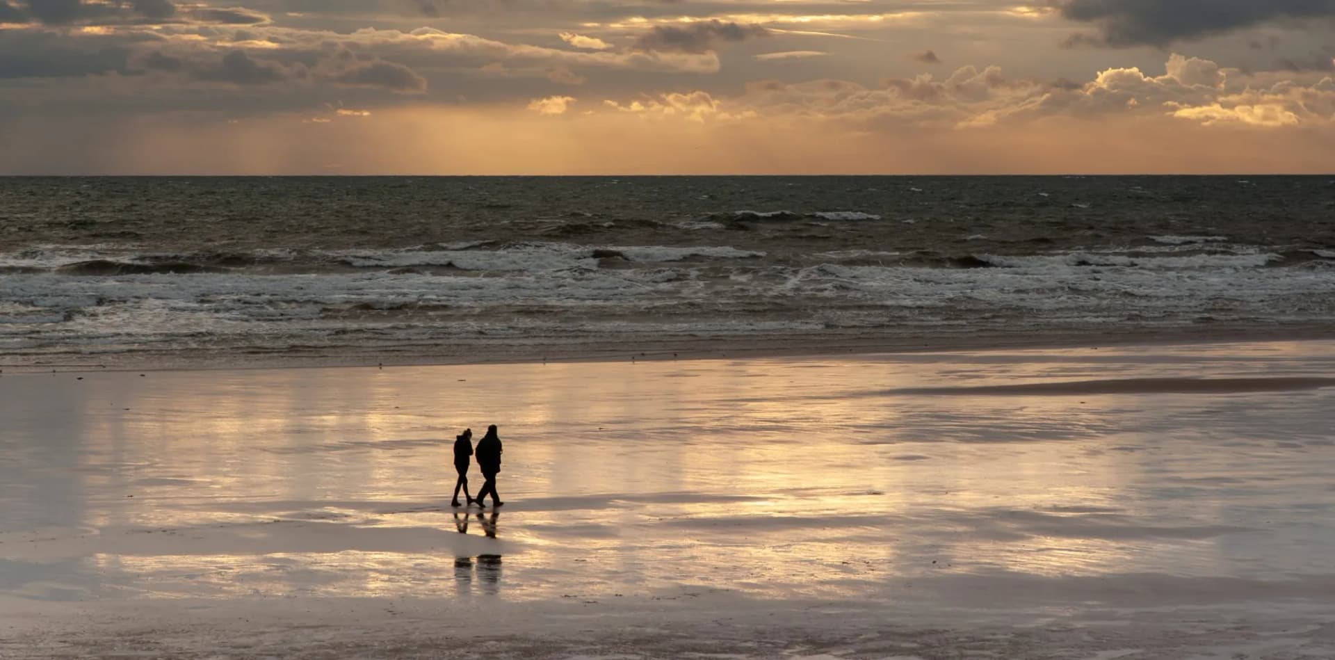Two walkers at dusk on St Bees beach 4602