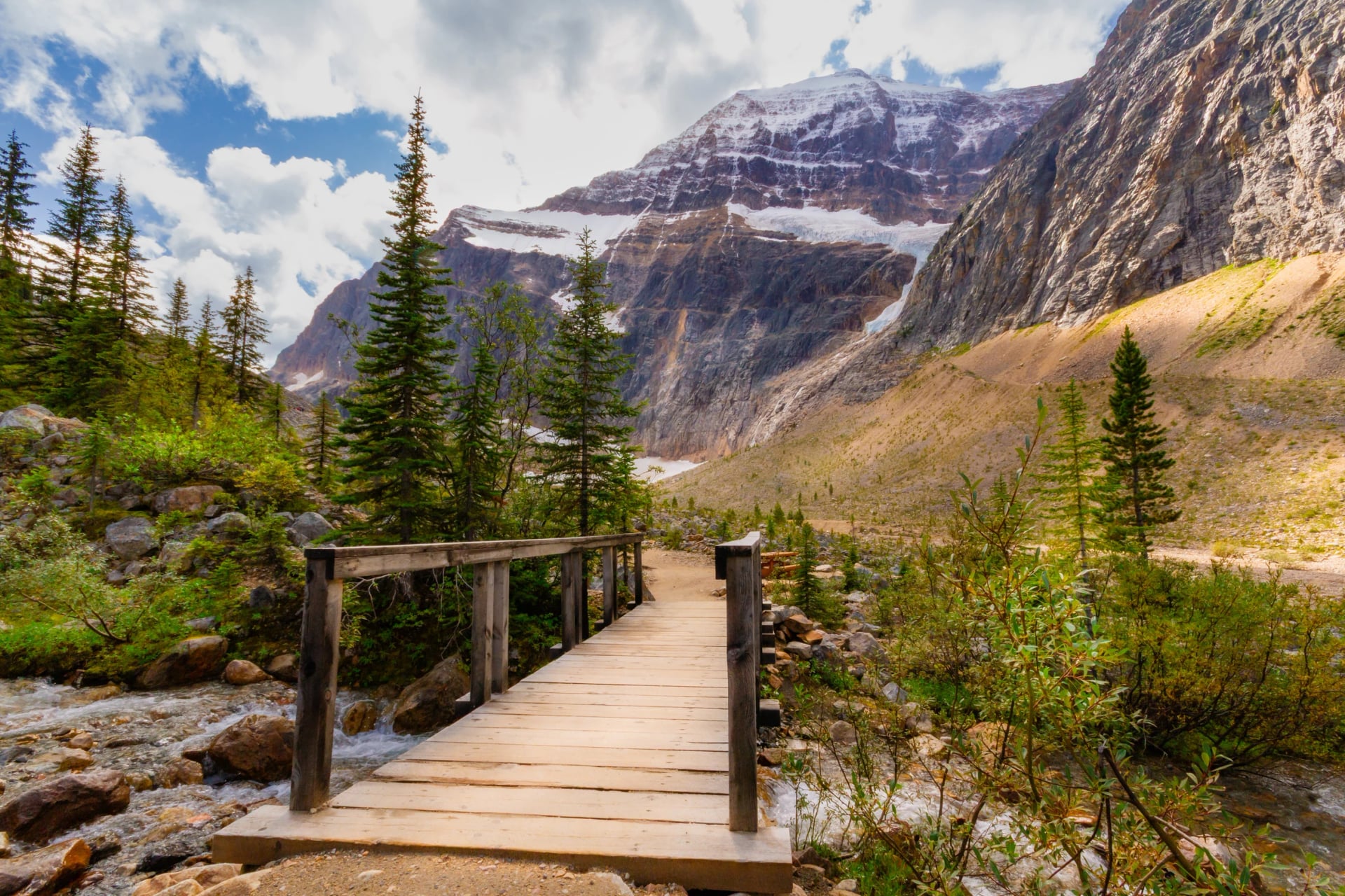 A small wooden bridge over a stream on a hiking trail Path of the Glacier. Mt Edith Cavell Meadows. Mt. Edith Cavell, Jasper National Park, Alberta, Canada.