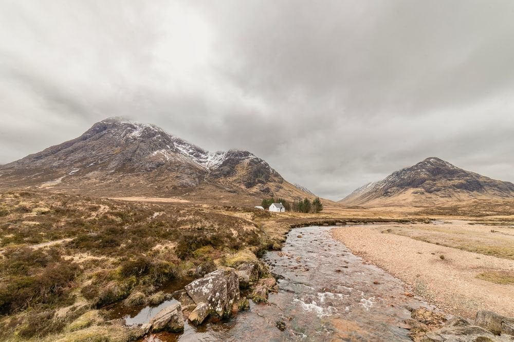 A stony path crossing open moorland below dark peaks