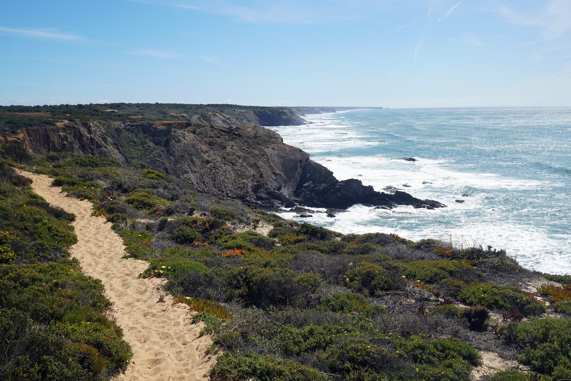 Hiking trail along rugged cliffs overlooking the Atlantic Ocean waves near Salema.