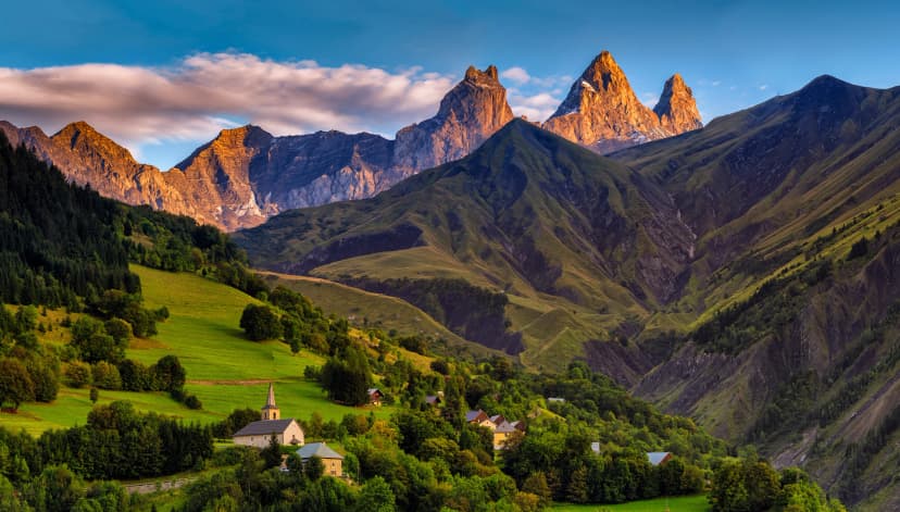 church in a village in the french alps with mountains 3000 meters high. Green meadows in spring