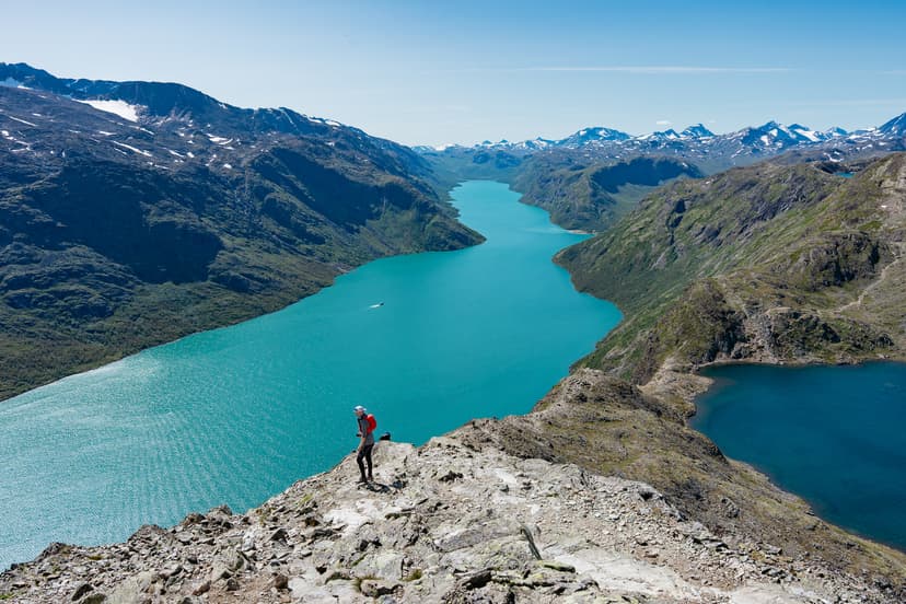 Hiker on Besseggen Ridge overlooking turquoise Gjende lake in Jotunheimen National Park, Norway