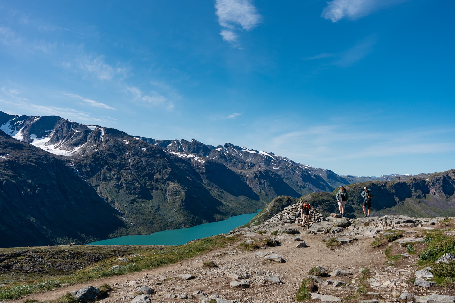 Hikers on Besseggen ridge above turquoise Lake Gjende in Norway