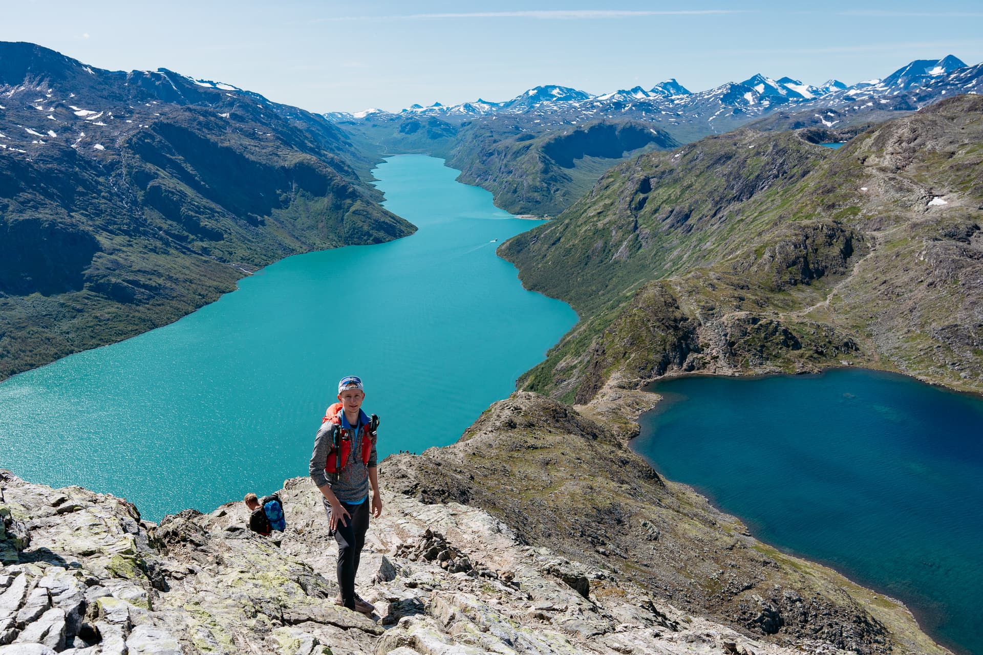 Hiker overlooking two lakes and mountain peaks at Besseggen in Norway