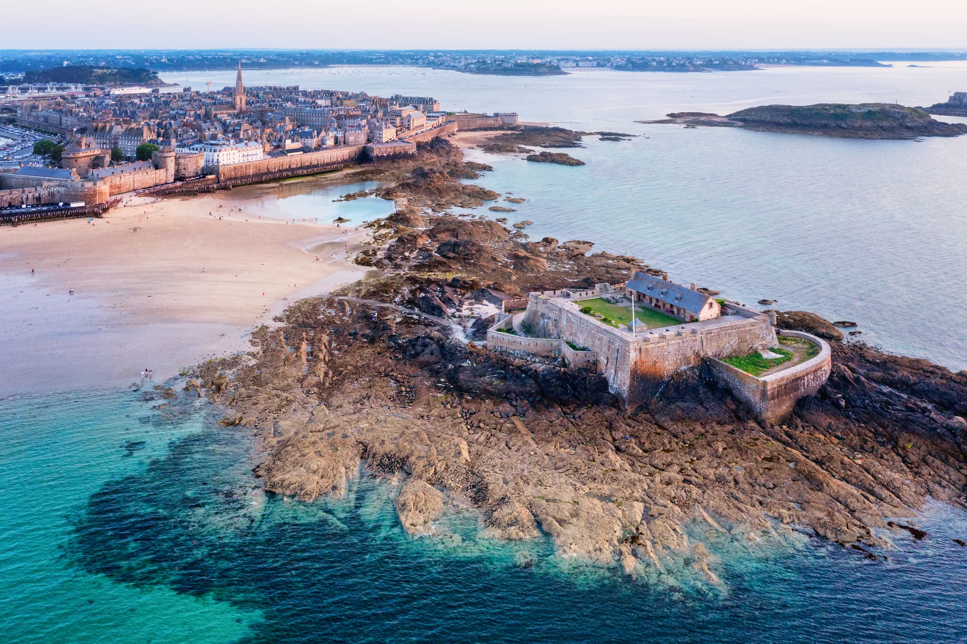 St Malo walled city, National Fort, and rocky coastline on the Atlantic coast of Brittany, France.